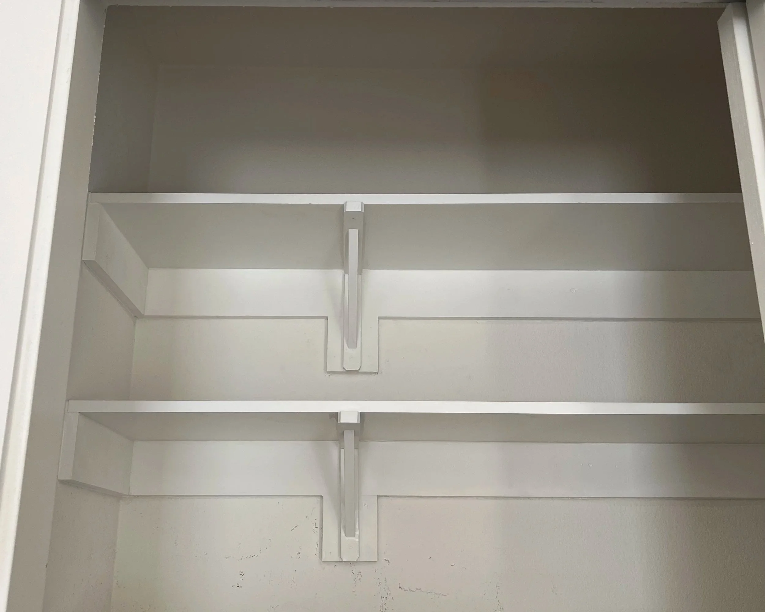 Two new white shelves added to a sliding closet