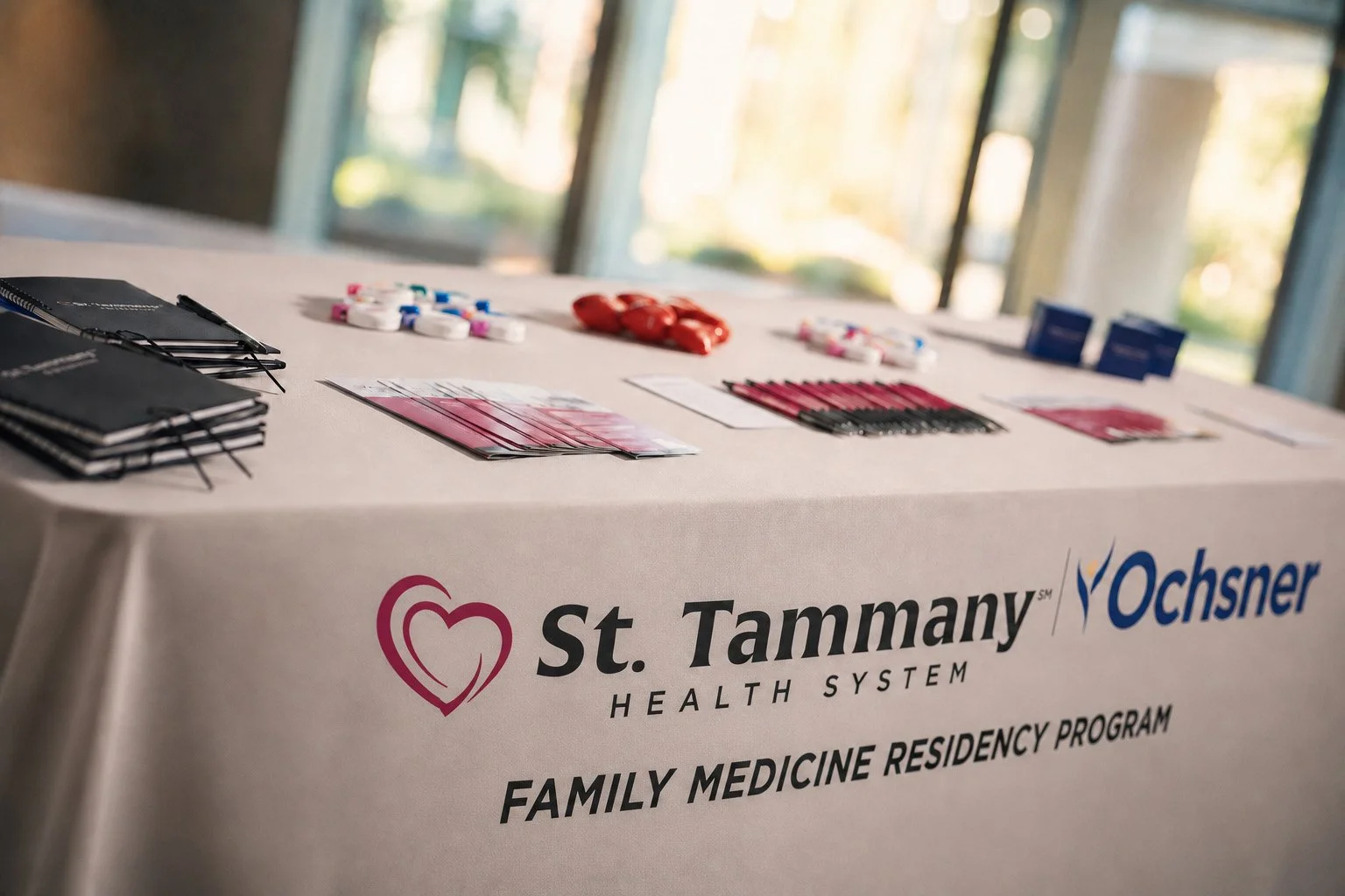 St. Tammany Health System and Ochsner Family Medicine Residency recruitment materials displayed on a branded event table.
