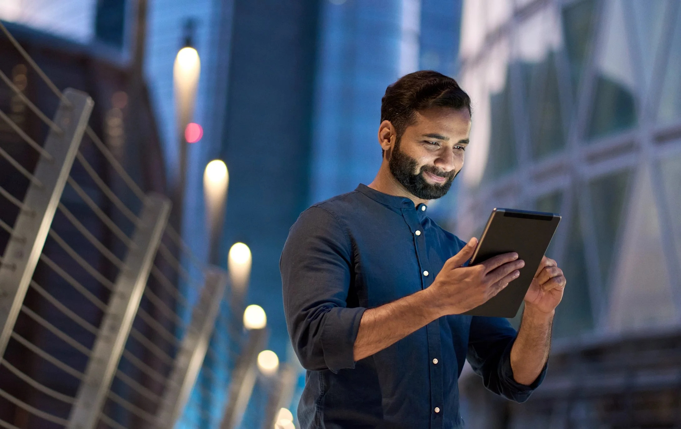 Professional reviewing digital data on a tablet in a modern office, representing financial technology solutions.