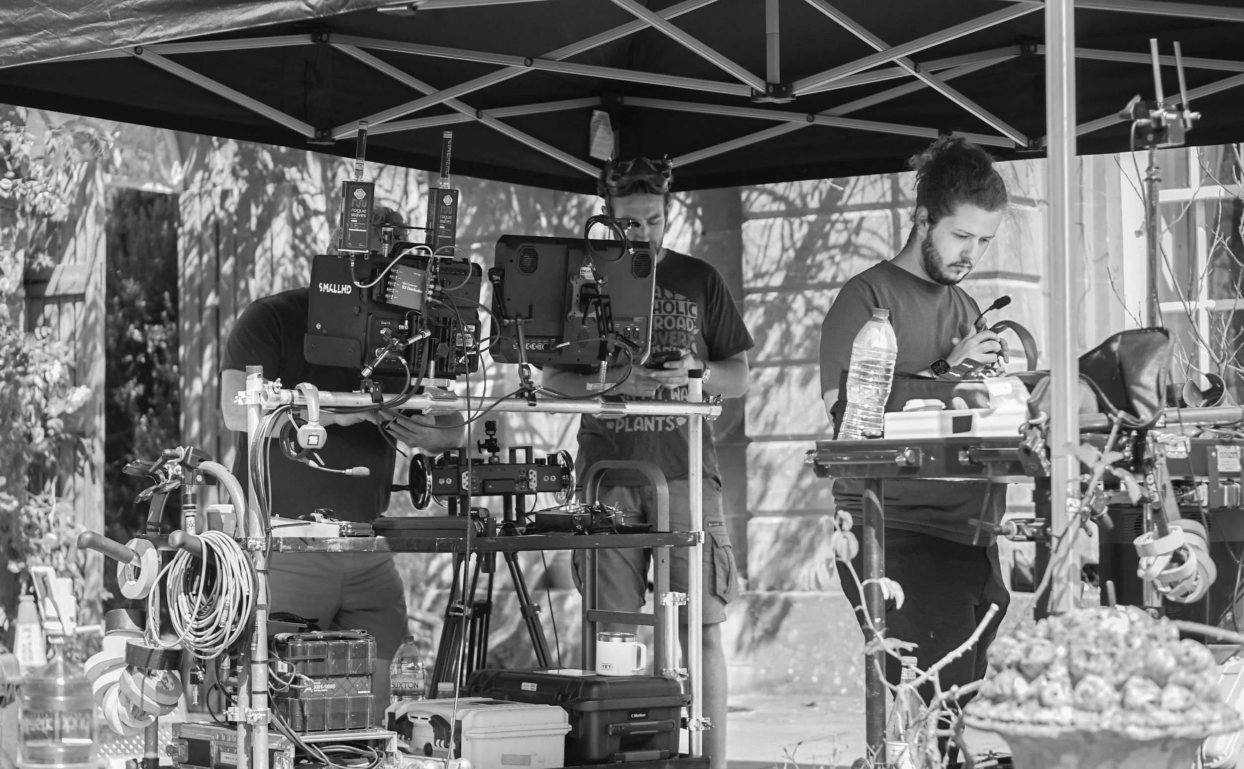 Stan Thornton and a Filmmaking crew working under a canopy with cameras, equipment, and tools