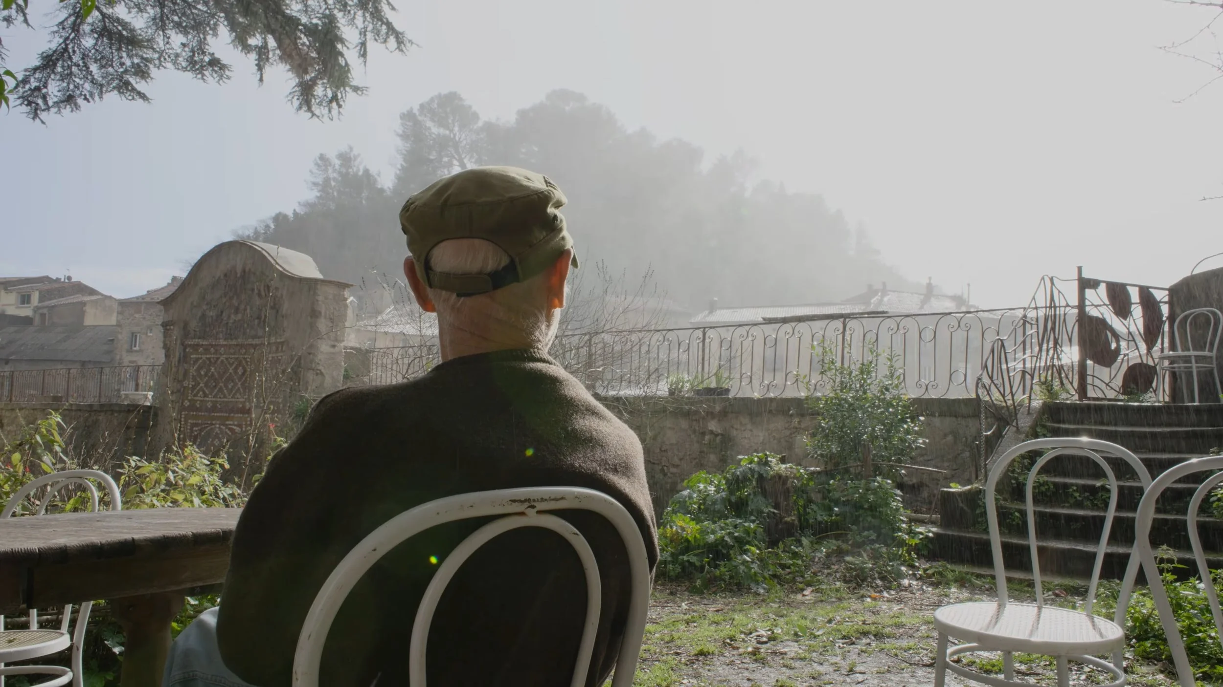 Grounded Media - An Unlikely Quartet Documentary still frame, drummer sat in a garden with sun and rain hitting him - by Stan Thornton