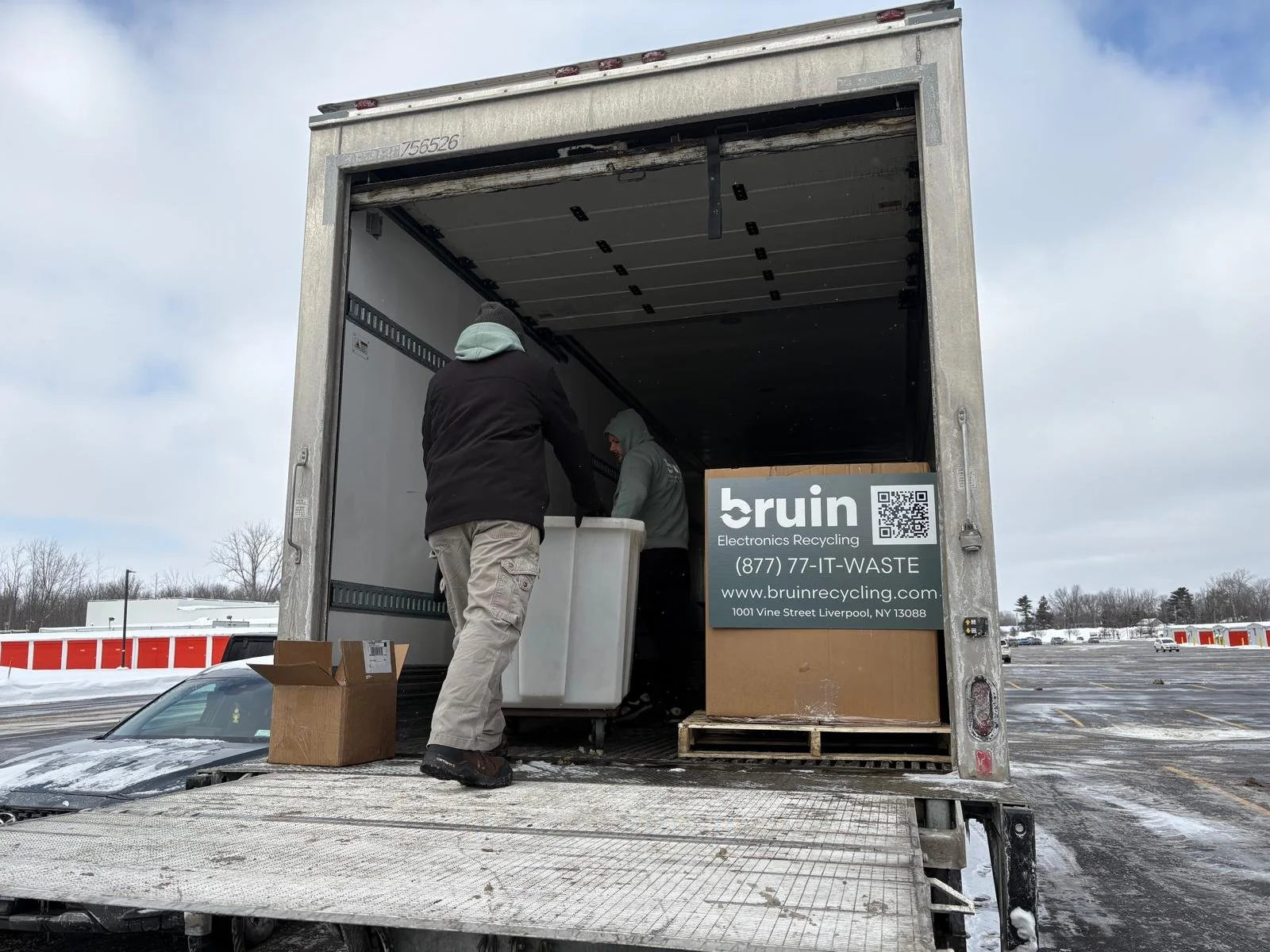 Man moving containers from truck with Bruin label