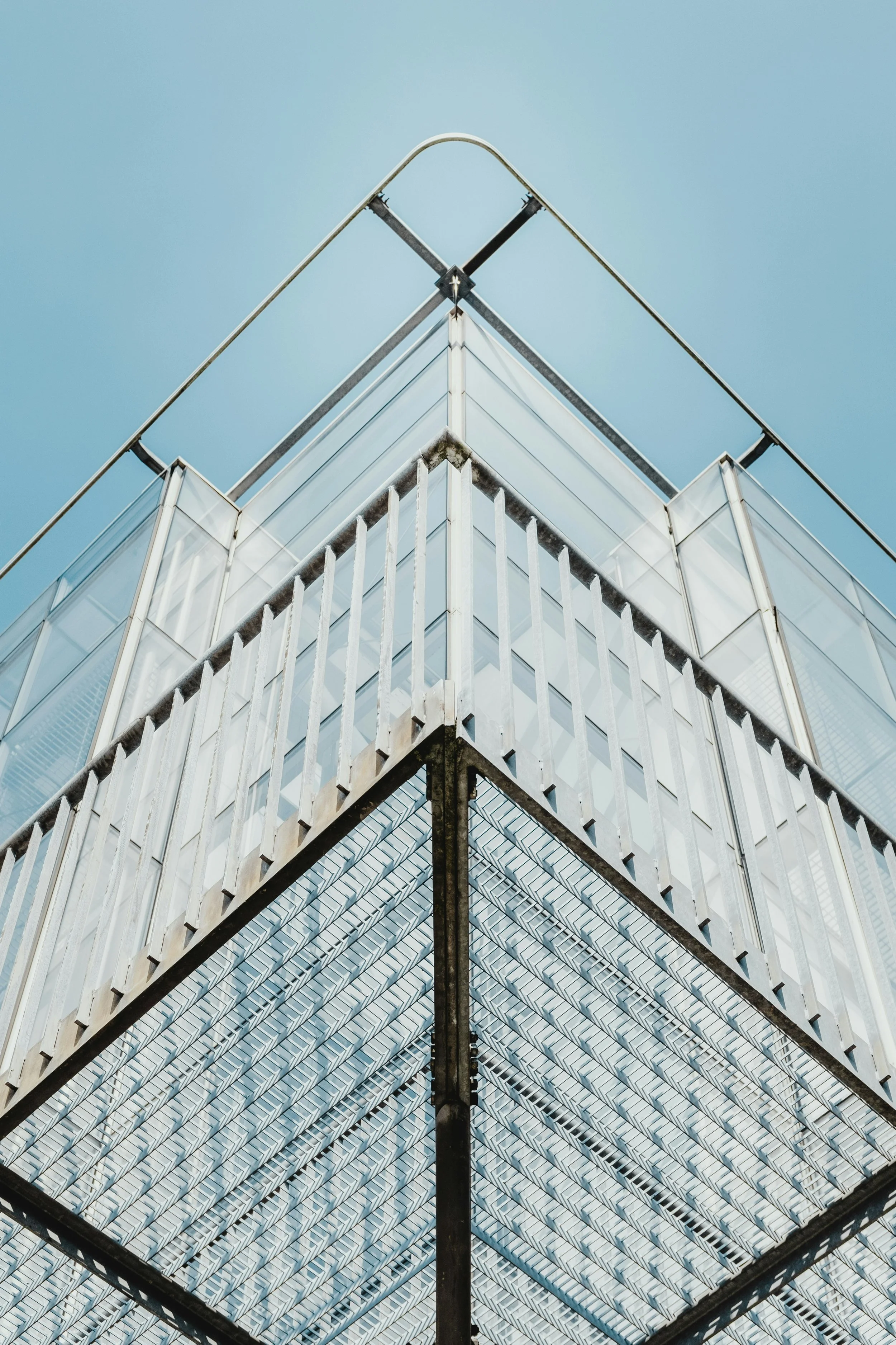 Low-angle view of a modern glass building against a clear blue sky.