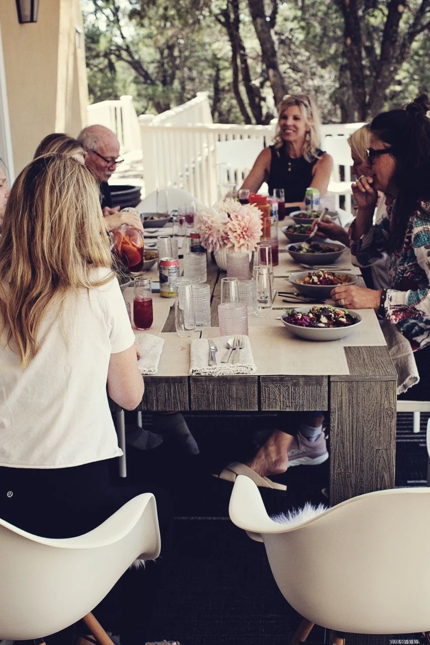 Courtney and clients around a table talking while eating a meal