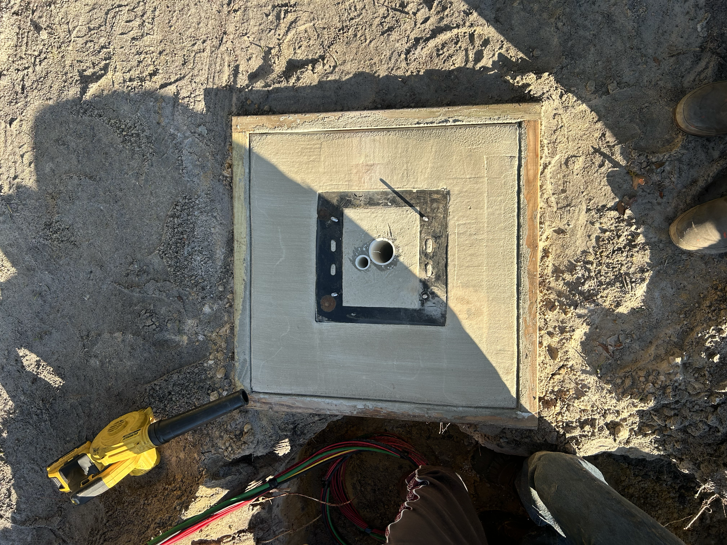 We repoured this pad for #14, moving it out of the fairway and across the cart path. This involved boring under the cart path as well as  putting the wires through a sleeve underneath and into the new box. 