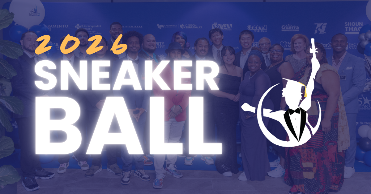 Group of people at a previous Sneaker Ball event, standing in front of a blue backdrop with sponsor logos, some holding balloons and dressed in formal attire