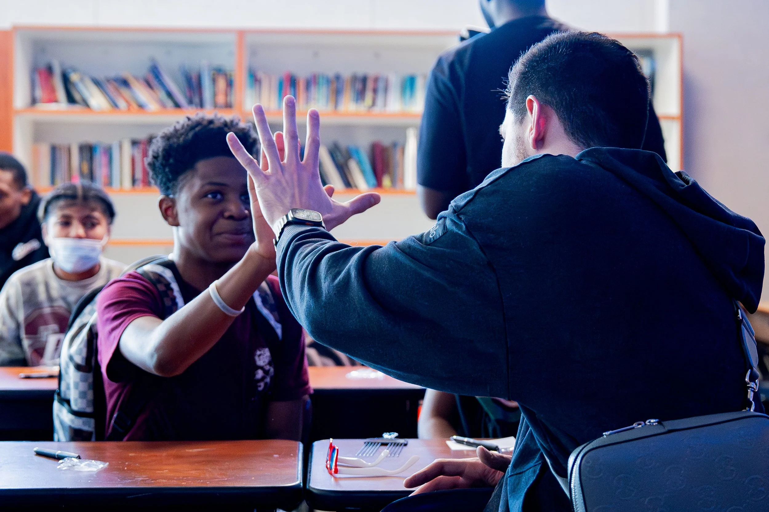 An IYT Brother compares hand sizes with an NBA player from the Sacramento Kings.