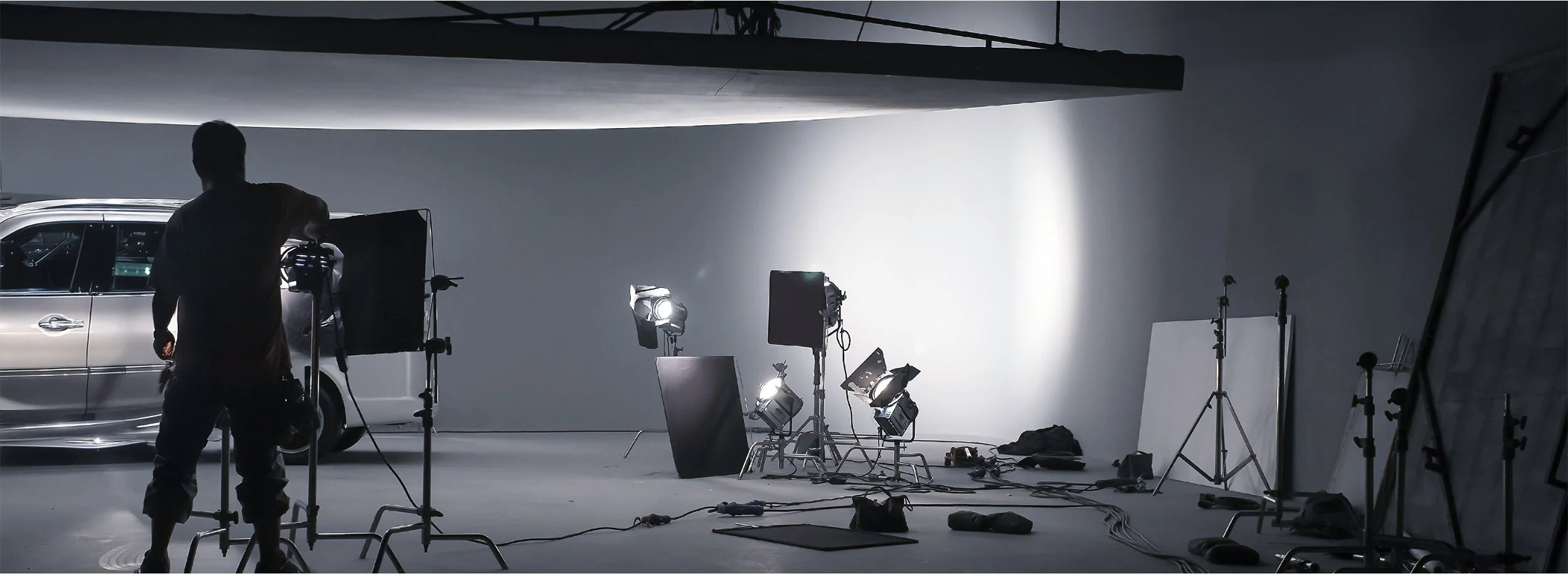 Un estudio de grabación con luces y cámaras, donde un equipo prepara una escena para grabar un video o sesión fotográfica.