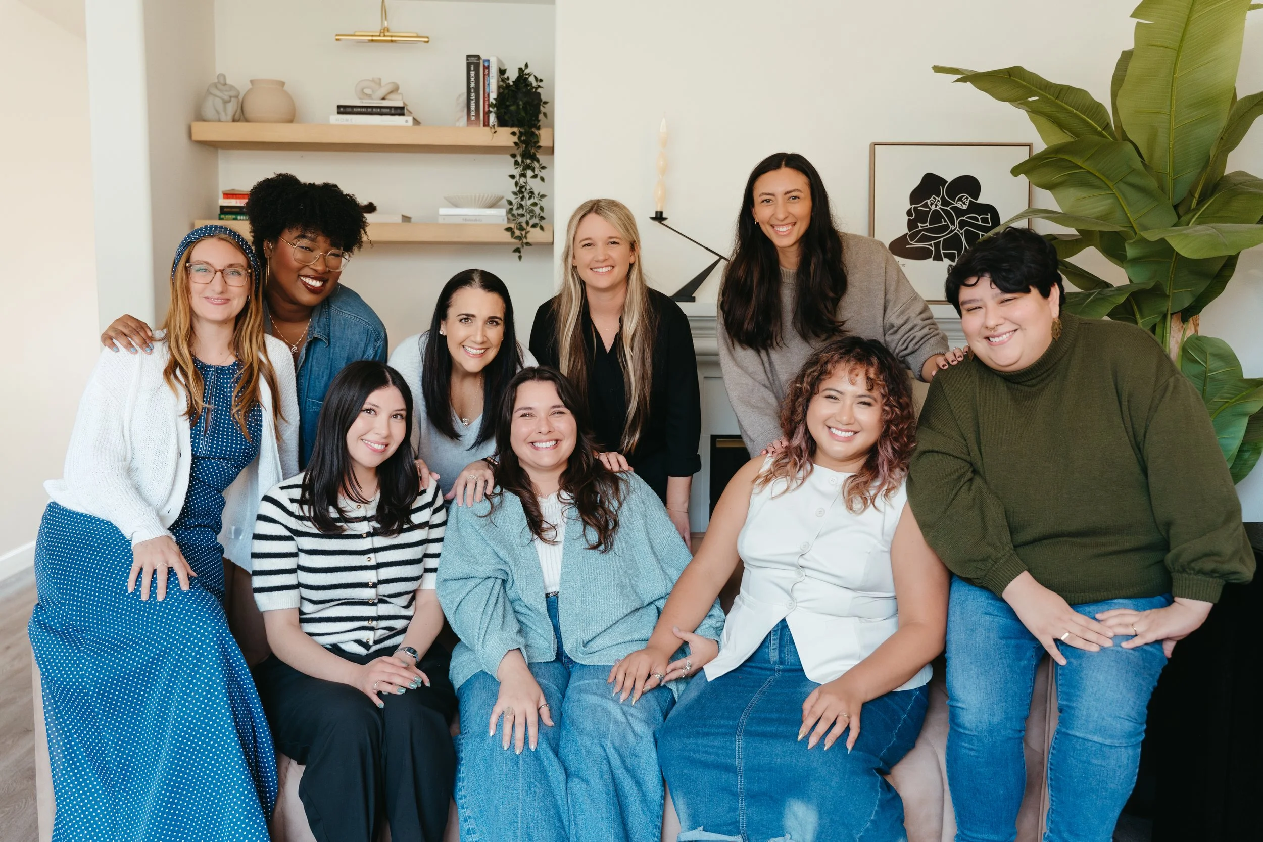 Photo of all of the Nido Individual & Family Therapy team crowded around a couch smiling