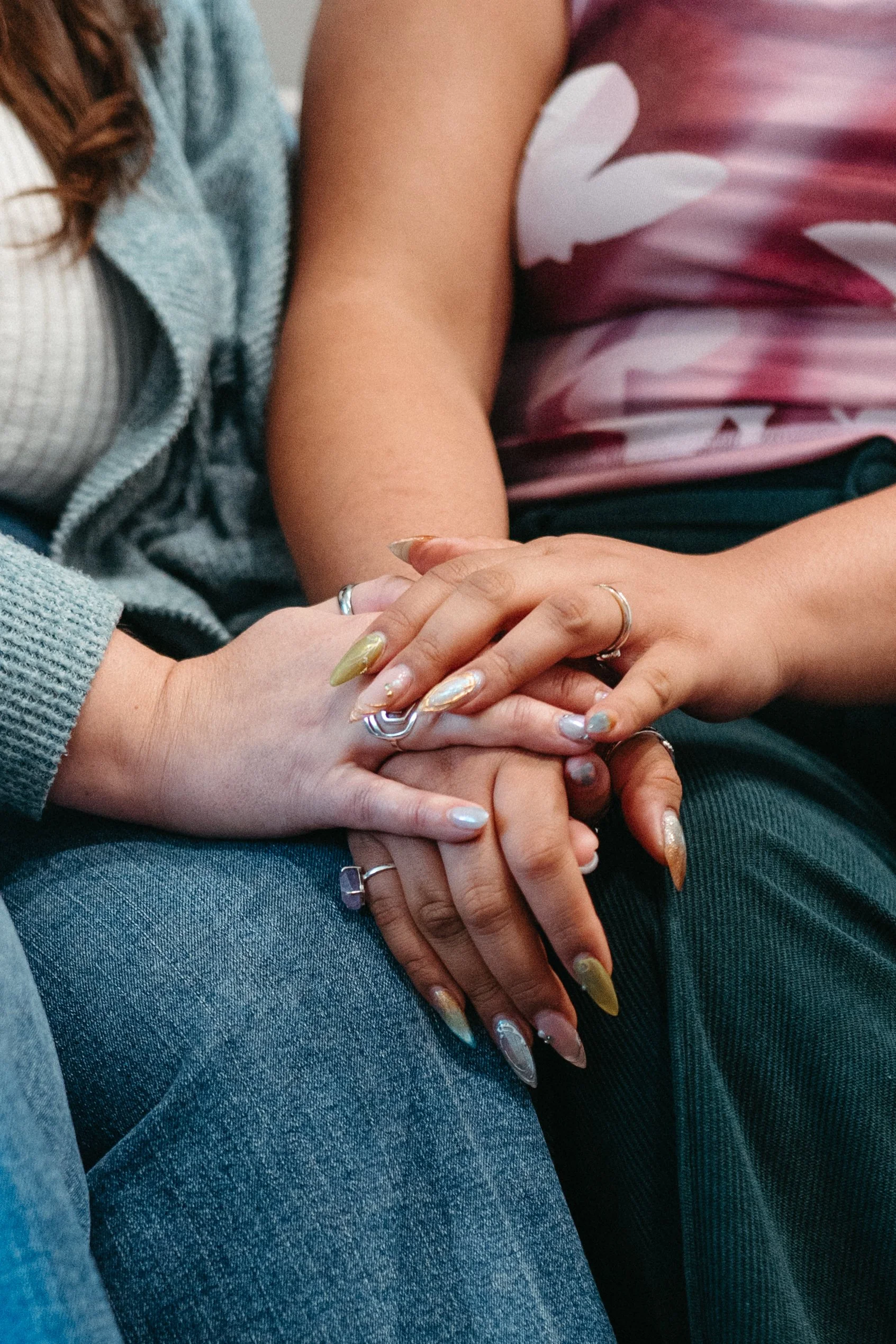 Photo of two sets of hands clasped in comfort