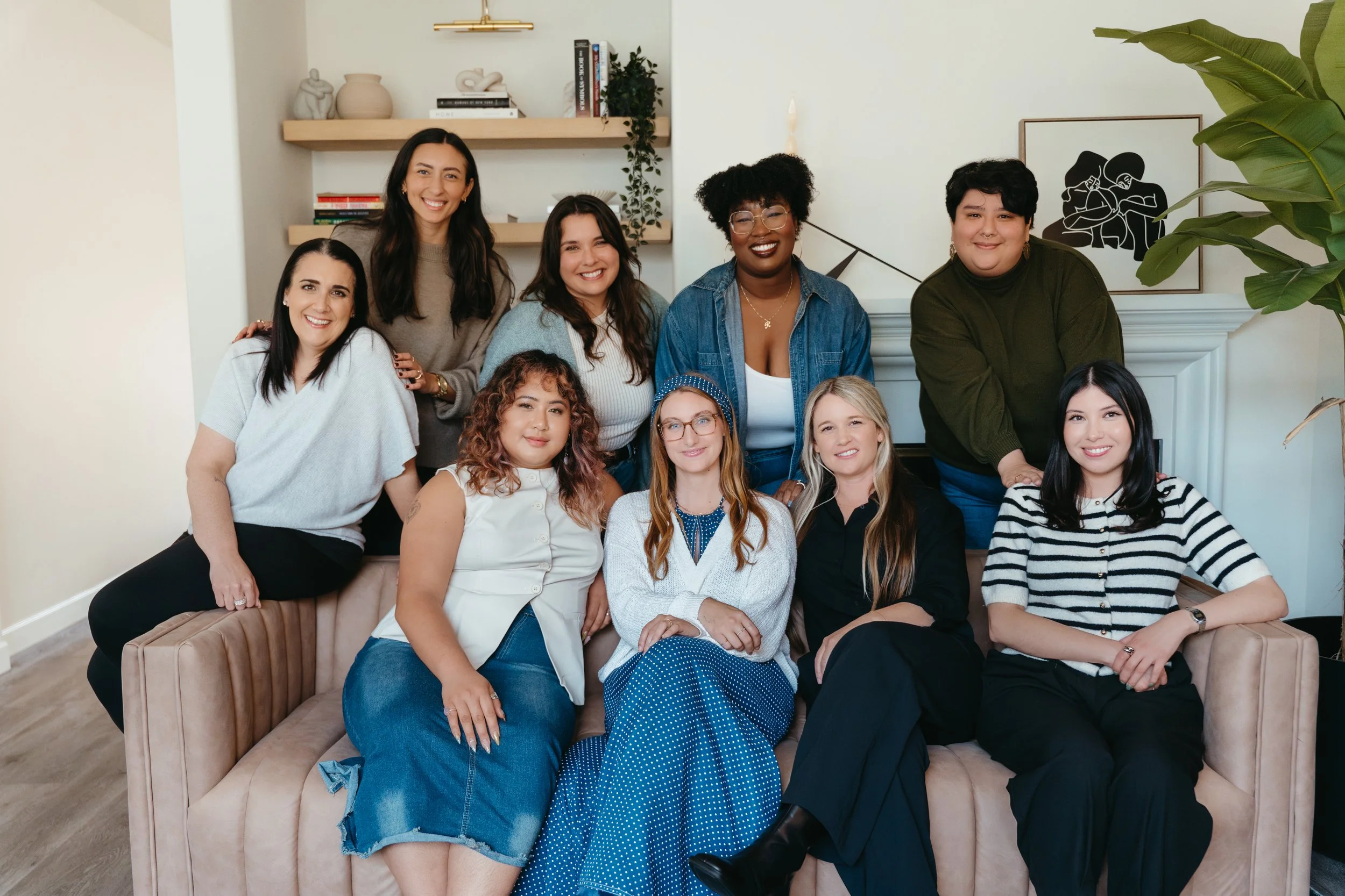 Photo facing the Nido Individual & Family Therapy team on a couch together and smiling