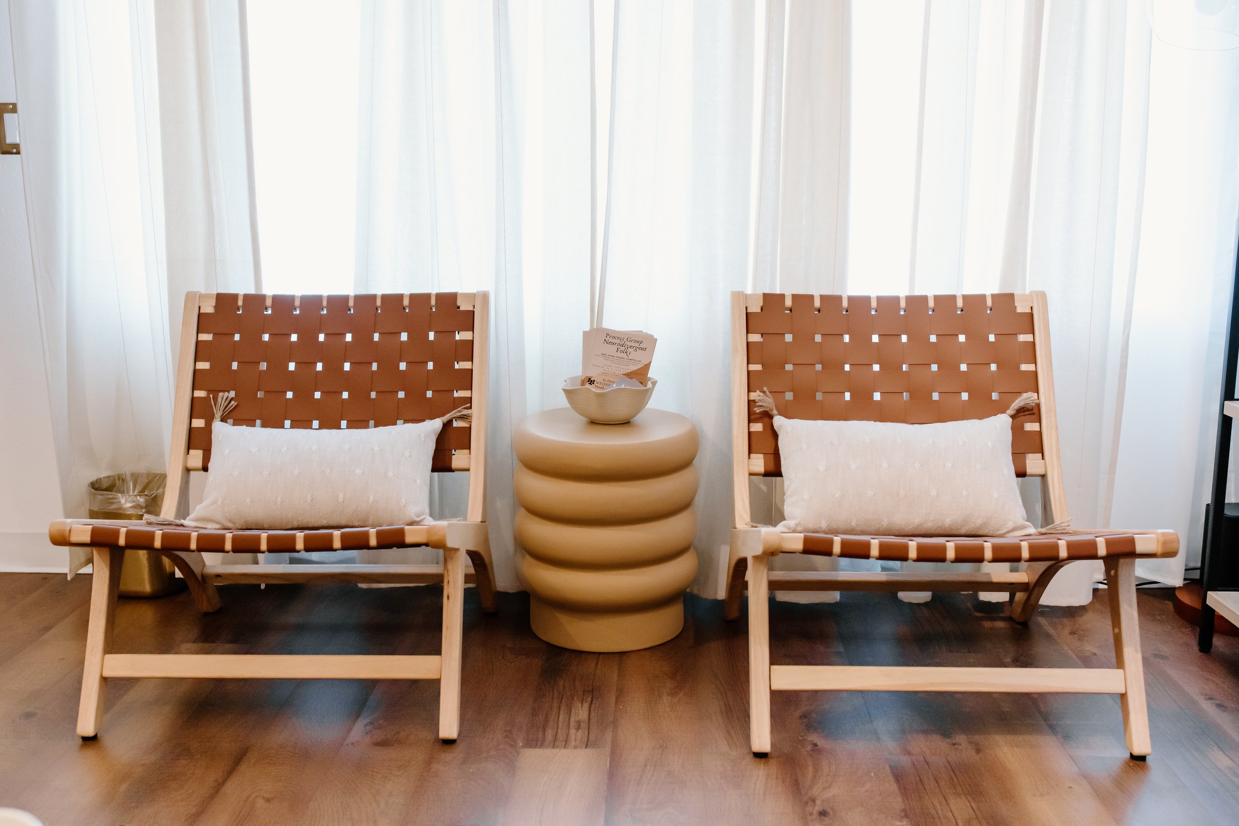 Photo facing two chairs in front of a gauzy white window