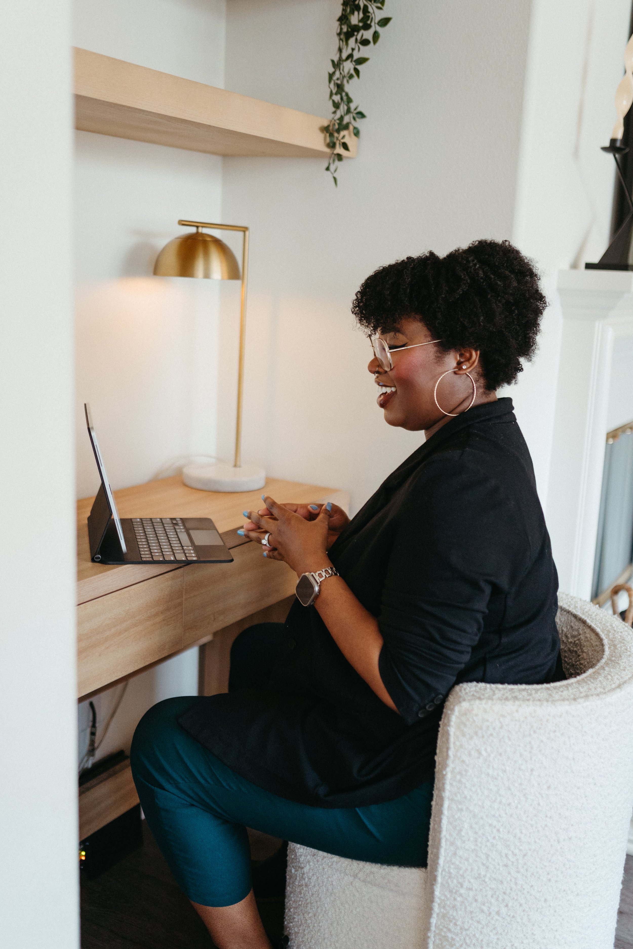 Photo of a Nido IFT therapist sitting at a desk and smiling on a virtual telehealth session
