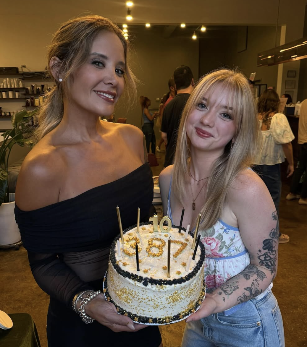 Salon 387 Owner, Elaine, and salon manager, Virginia hold a birthday cake with a 10 candle