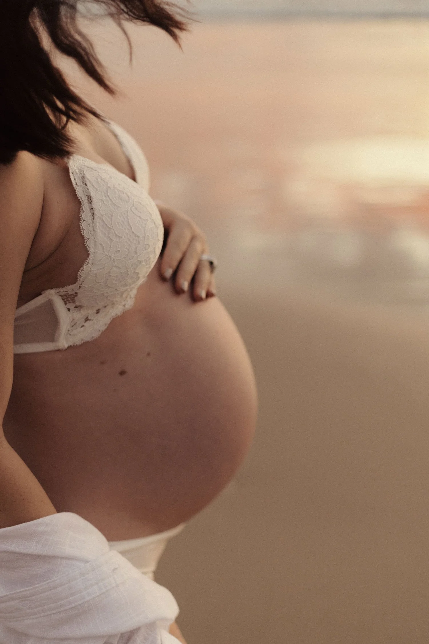 An maternal photoshoot in the beach during sunset.