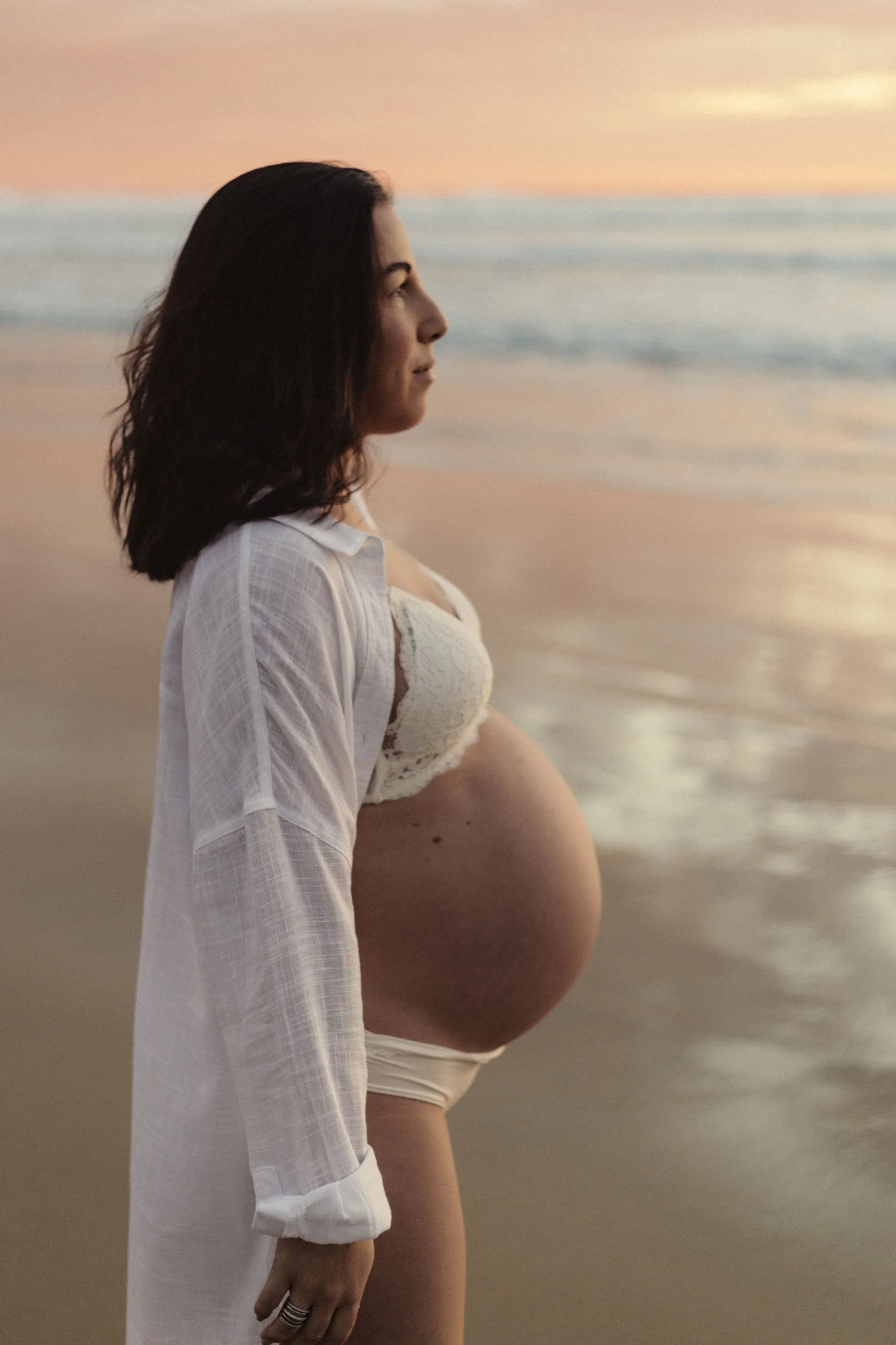 A pregnant women in a premium maternal shoot in the beach.