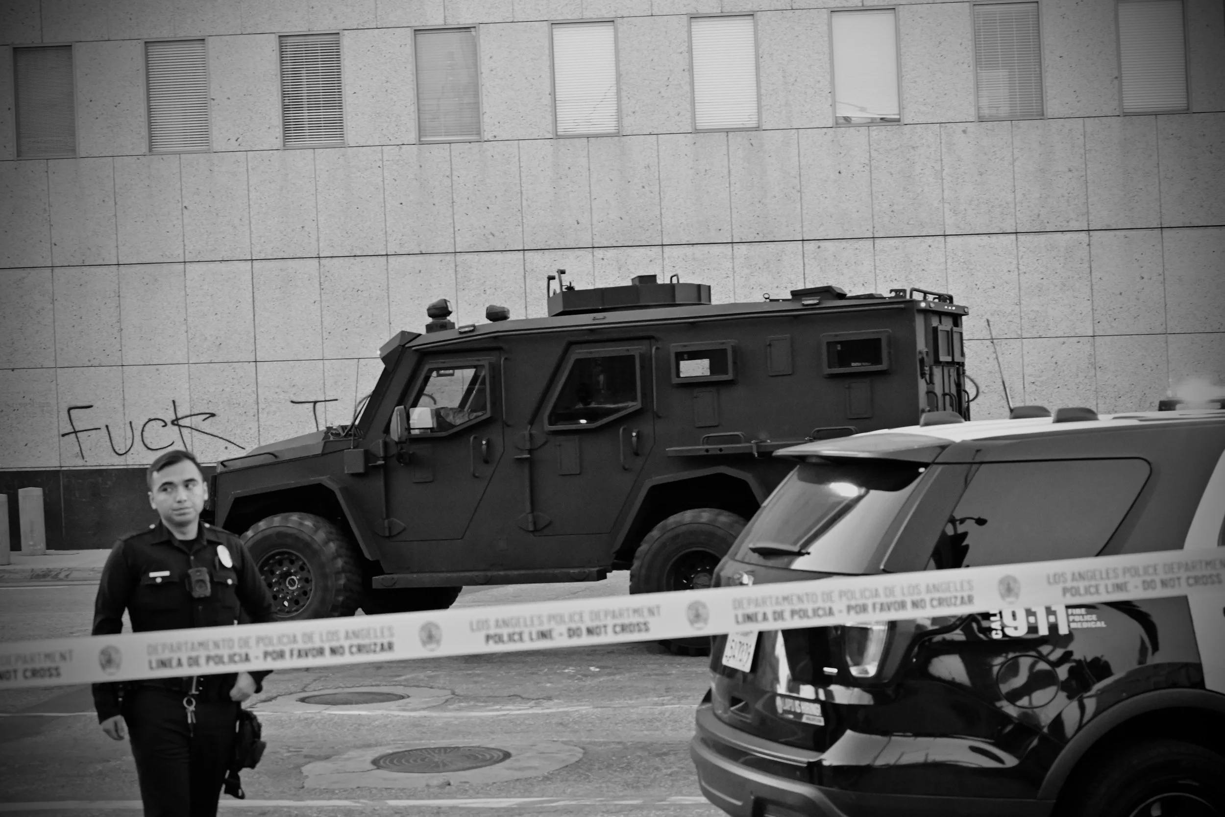 As LAPD officers establish a perimeter, ICE Special Response Team officers arrive in a BATT-X, a heavily armored, Ford F-550 based personnel carrier used by law enforcement and SWAT units. The vehicle transports ICE’s SRT to the scene as a protest es