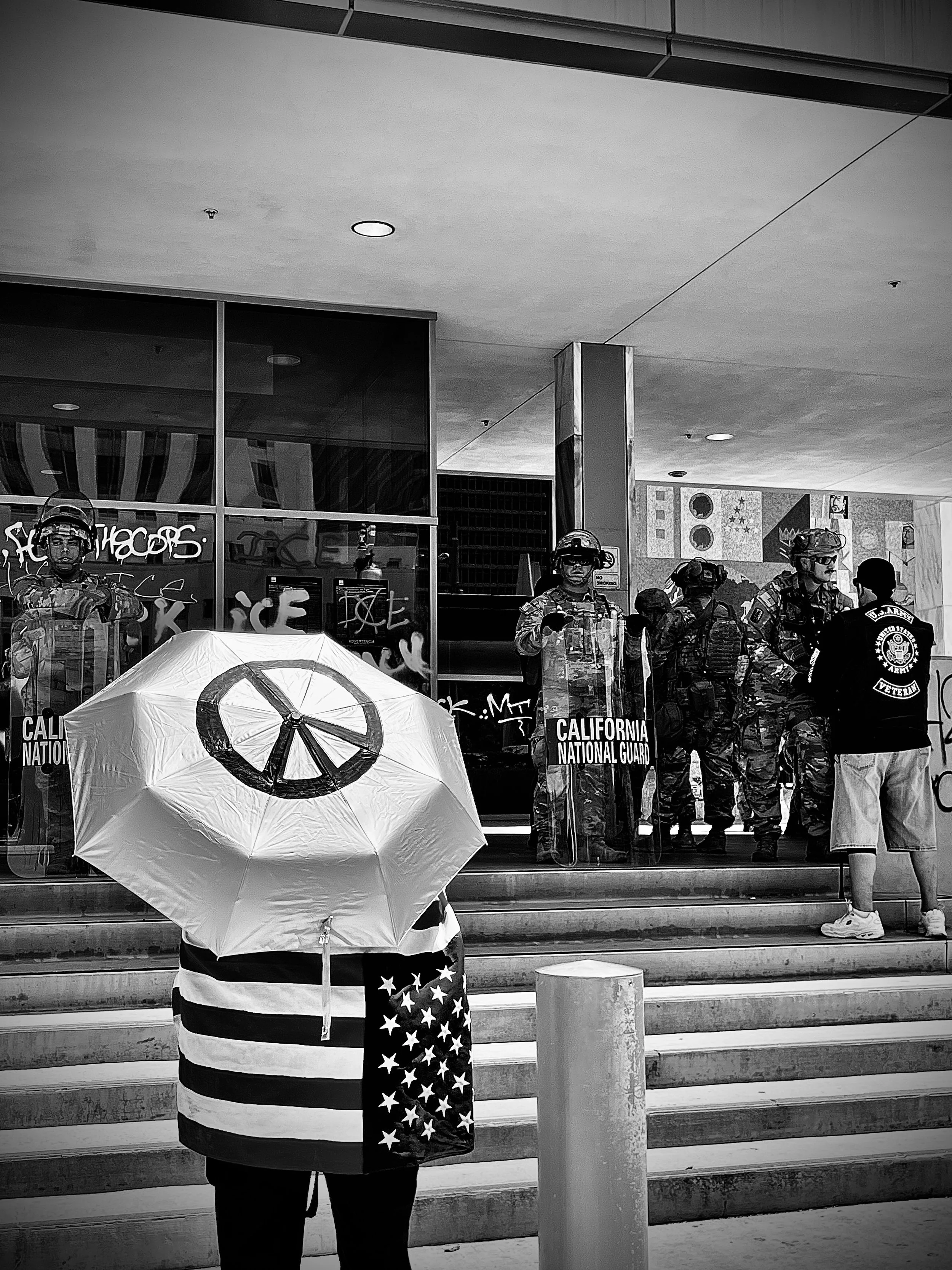 U.S. Army veteran walks up the steps of the Immigration and Customs Enforcement building, while the California National Guard has the entrance blocked off. (Los Angeles, June 2025)