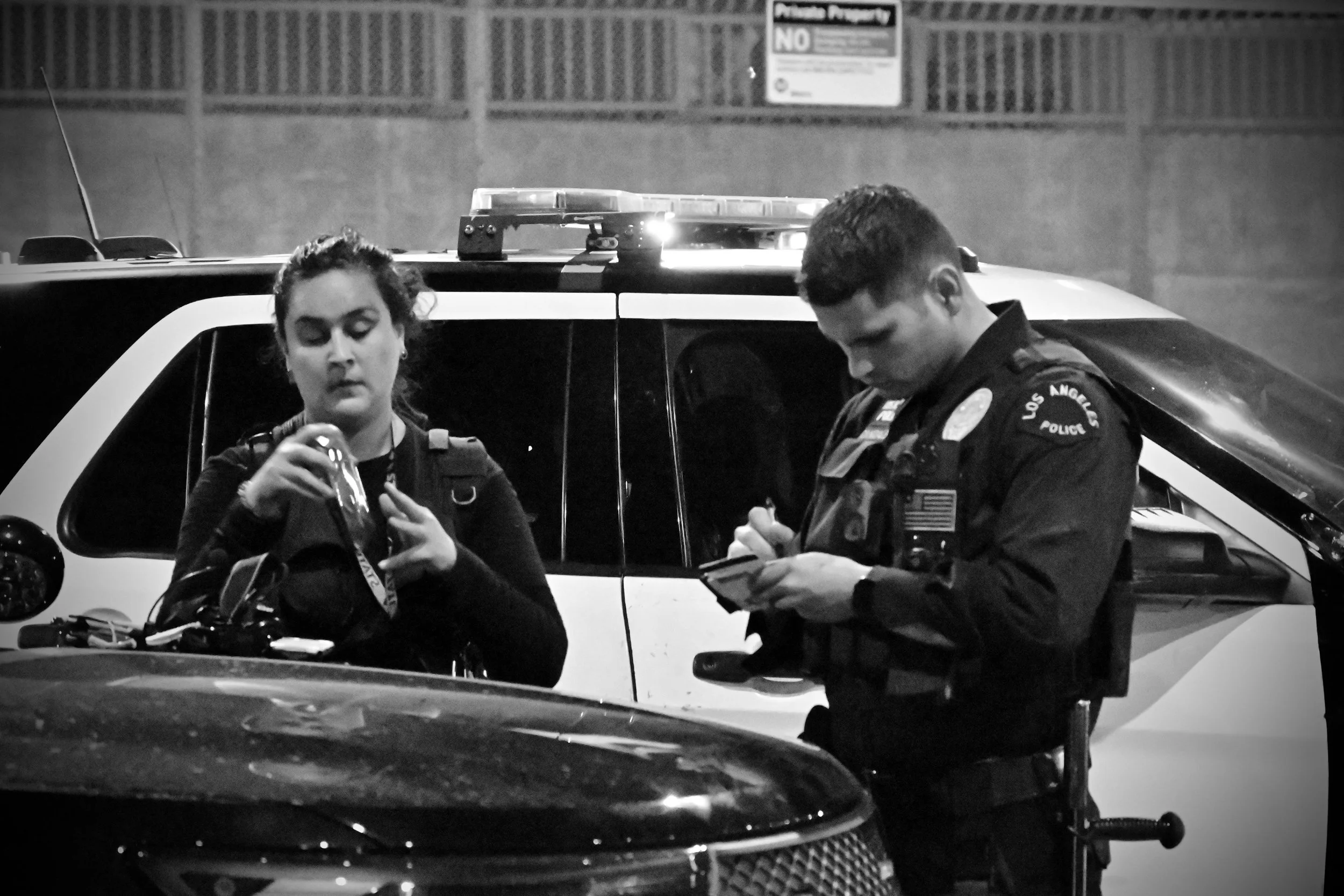 A woman accused of being a far-right agitator was assaulted and is shown speaking with an LAPD officer. Earlier, protesters had blocked her from crossing the street, accusing her of taking photos and doxxing to create propaganda for far-right media a