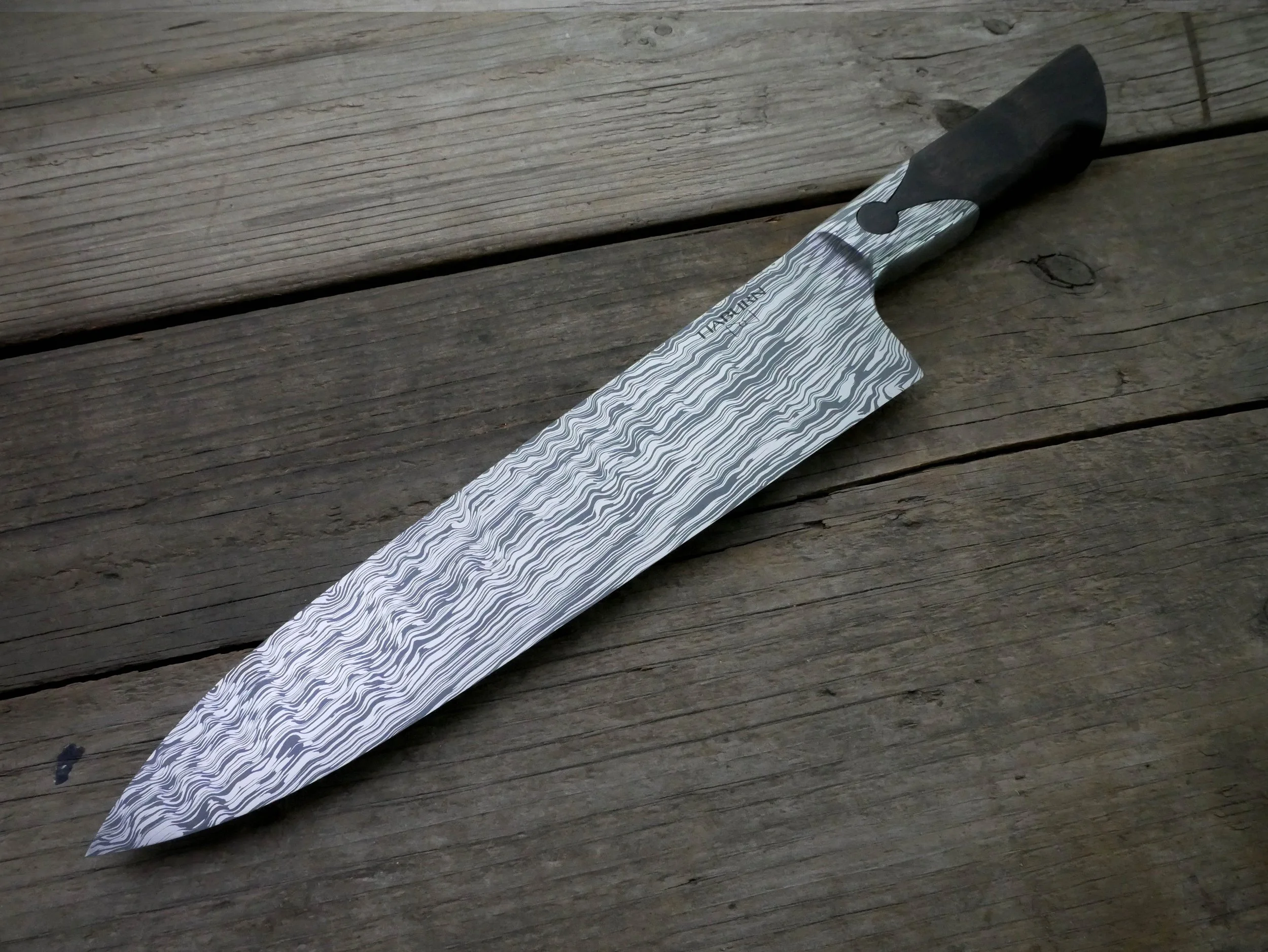 CPM154/AEB-L Stainless damascus Western gyuto. The handle features an integral keyhole holding beautiful African blackwood. 