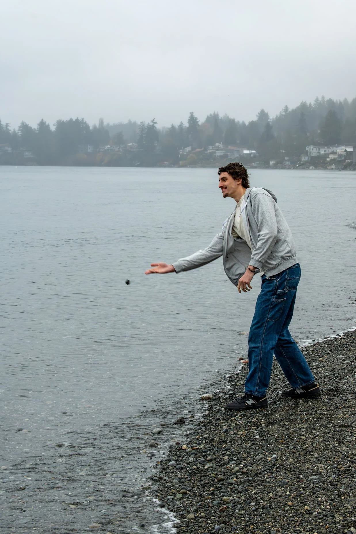Mike Pasek, past life regression therapist, skipping a rock over the ocean.