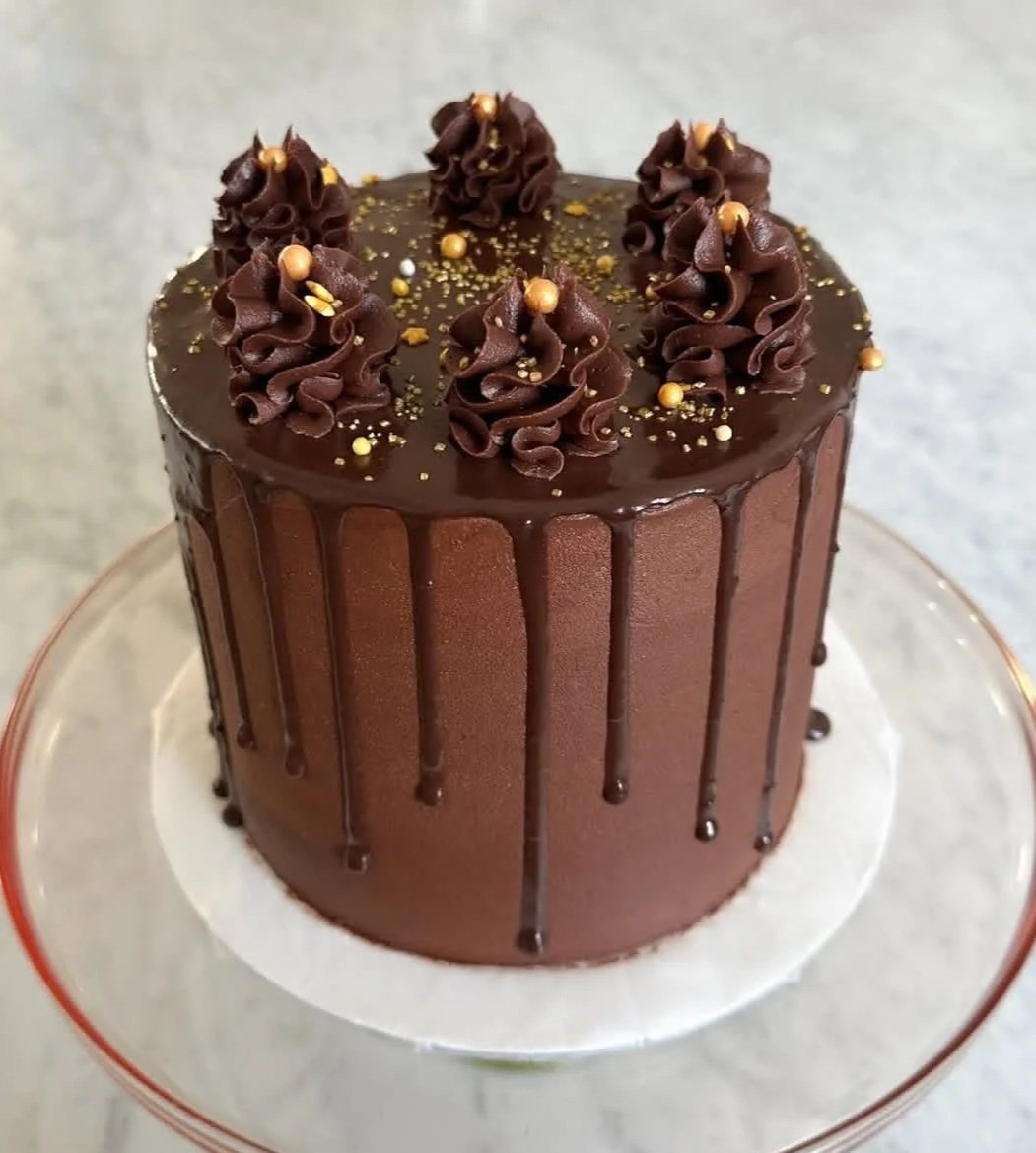  Chocolate Luxe Drizzle    
Rich chocolate layers draped in a silky ganache drip, topped with gold flakes for an indulgent touch.