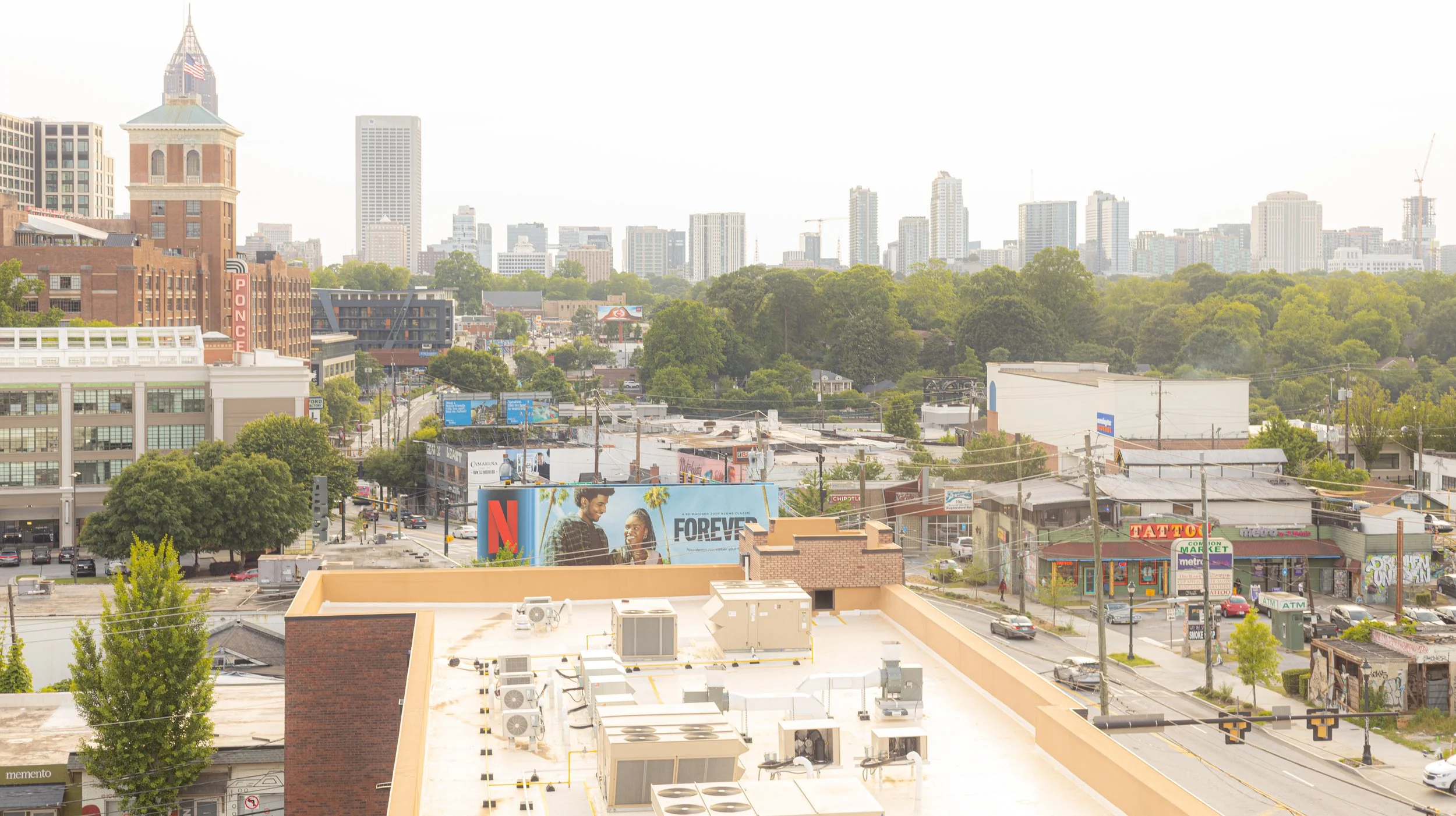 Two people working at a wooden desk with a lamp, notebooks, glasses of water, a mug, and a laptop.