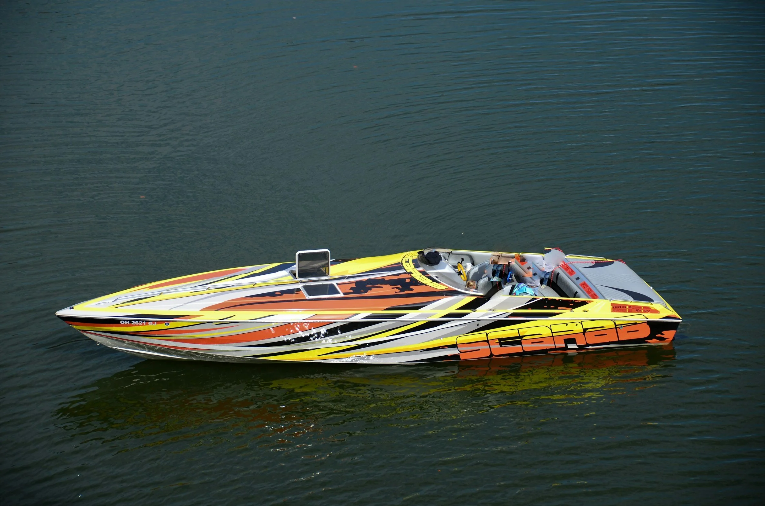 Colorful speedboat with the word 'scarb' on the side, floating on calm water.