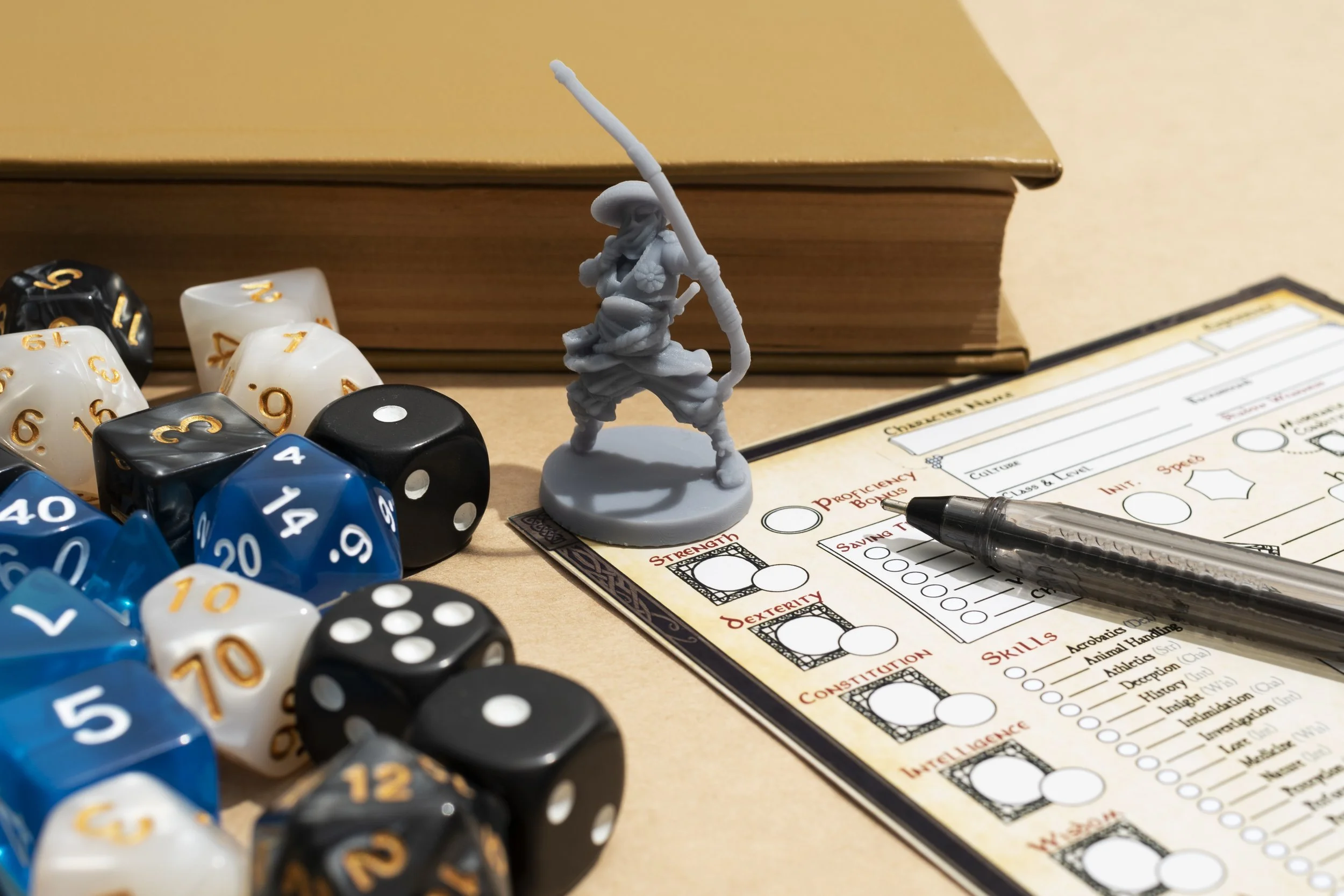 A tabletop game setup with a miniature archer figurine, a stack of books, various polyhedral dice, a character sheet, and a pen.