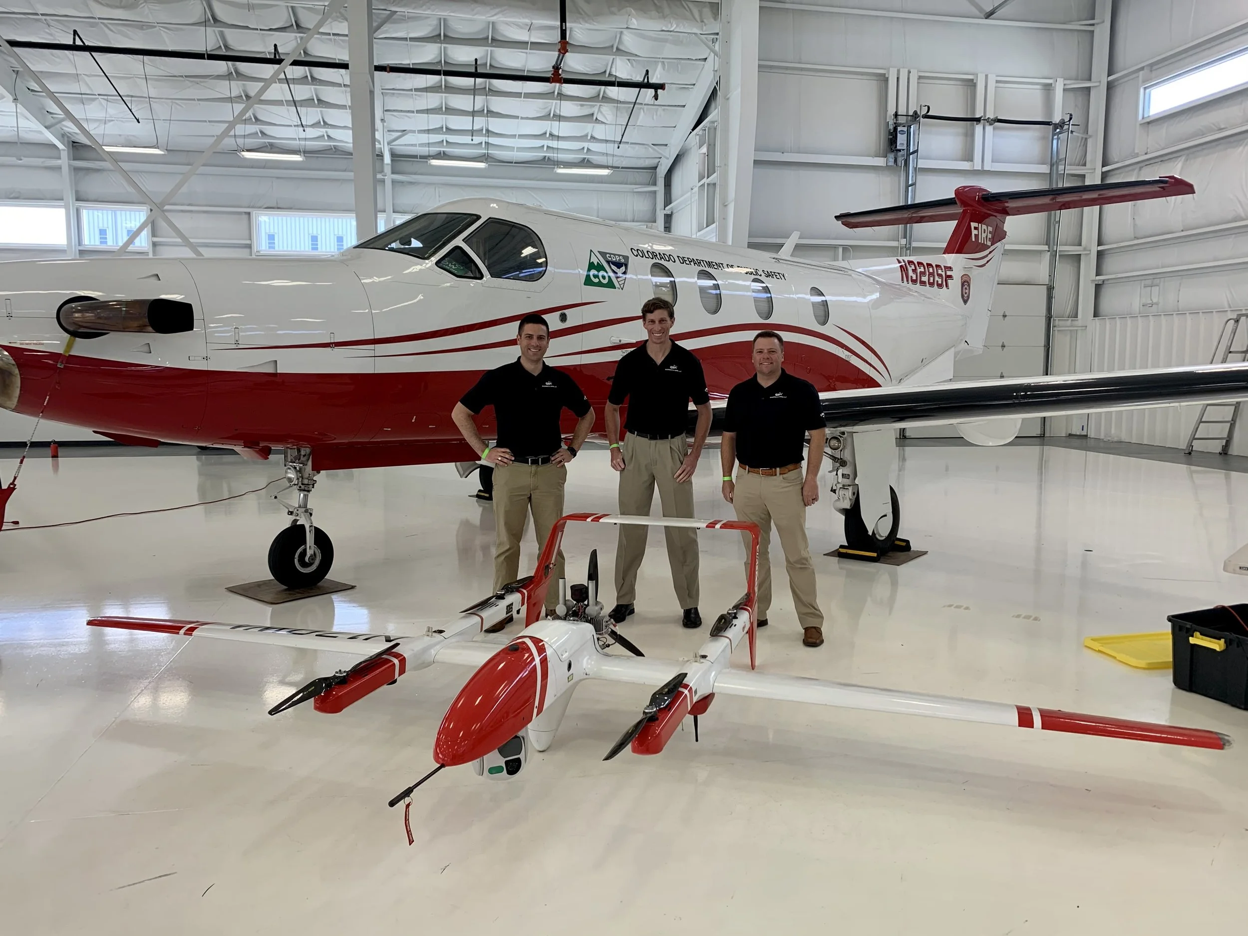 OWA flight crew standing next to manned aircraft and UAS