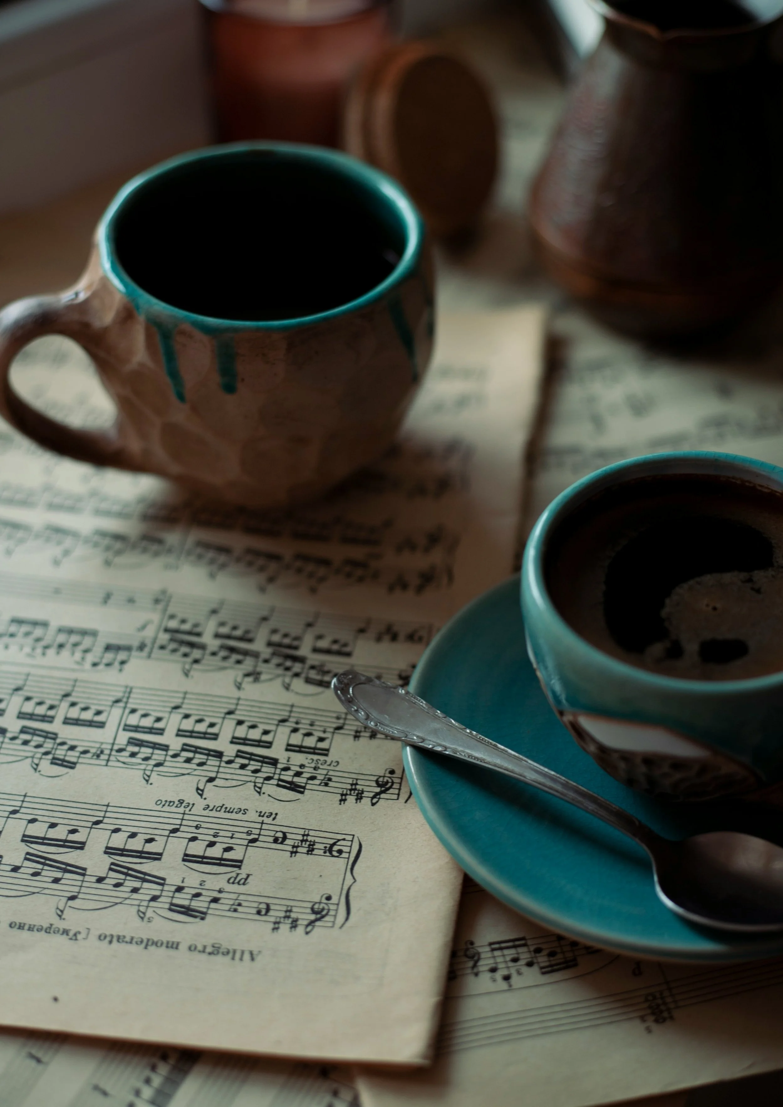 tea cups on a table with musical notation