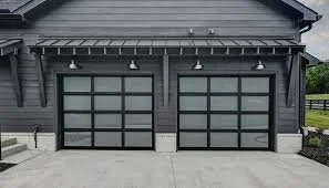 A modern gray garage with two glass-paneled doors and a concrete driveway.