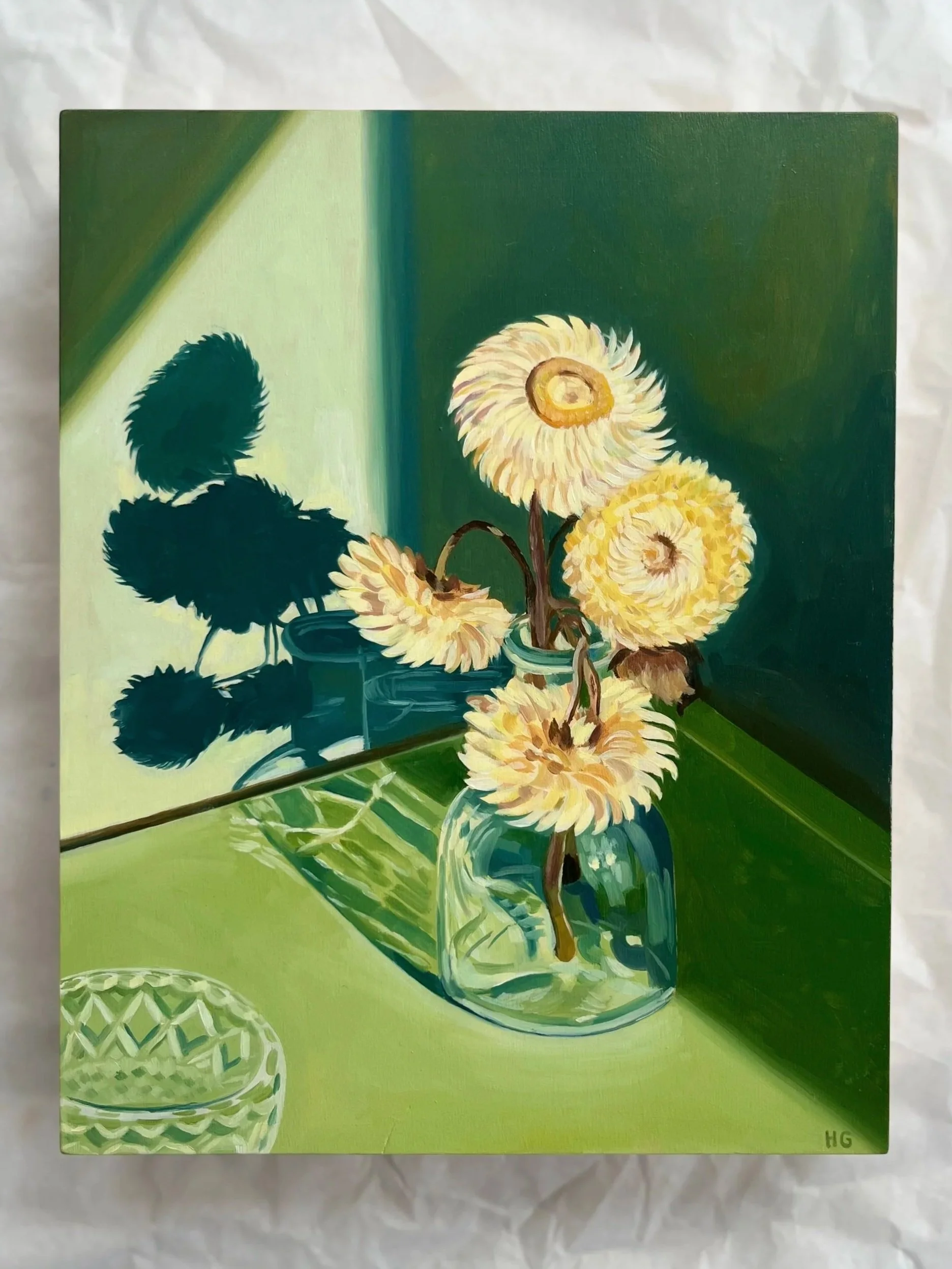 Paper daisies in glass bottle