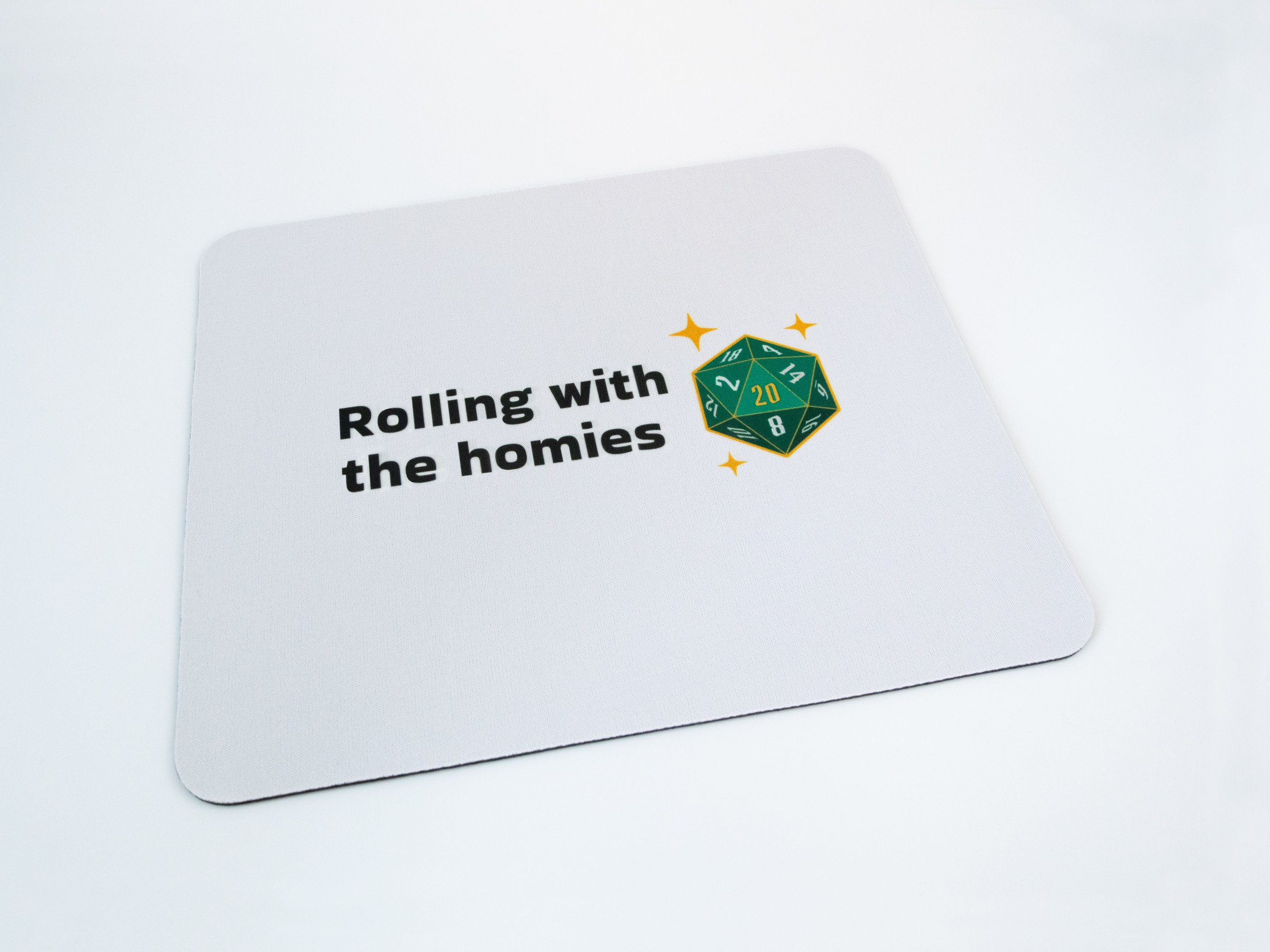 A sublimated mousepad. The design says “Rolling with the homies” and features a green d20 die