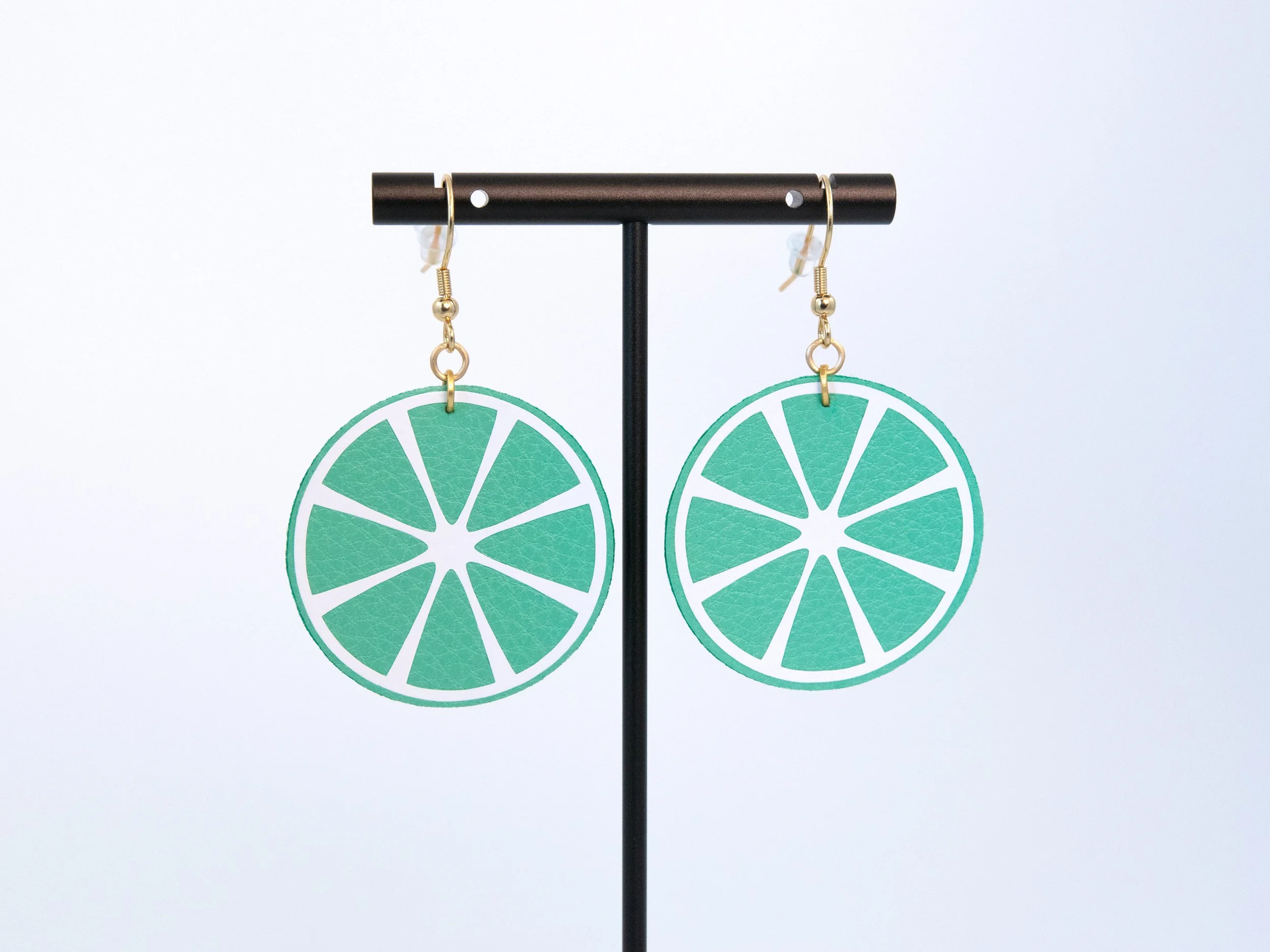 Citrus earrings made from green faux leather and white vinyl