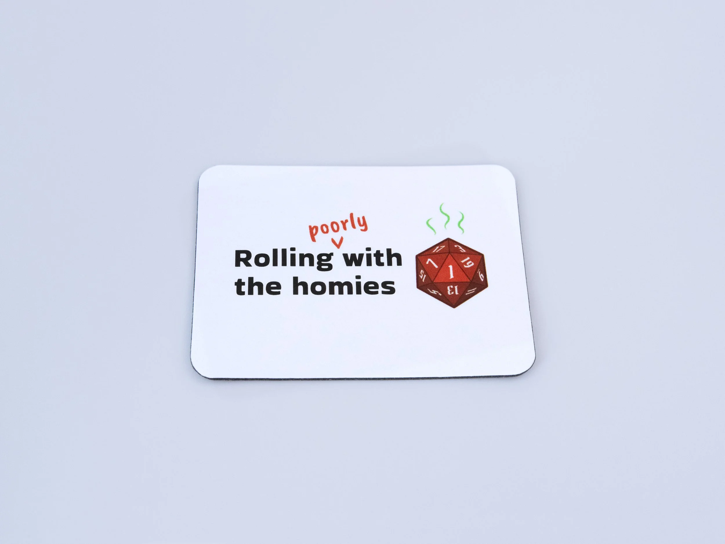 Top view of a magnet. The design is a red d20 die with text that says “Rolling poorly with the homies”