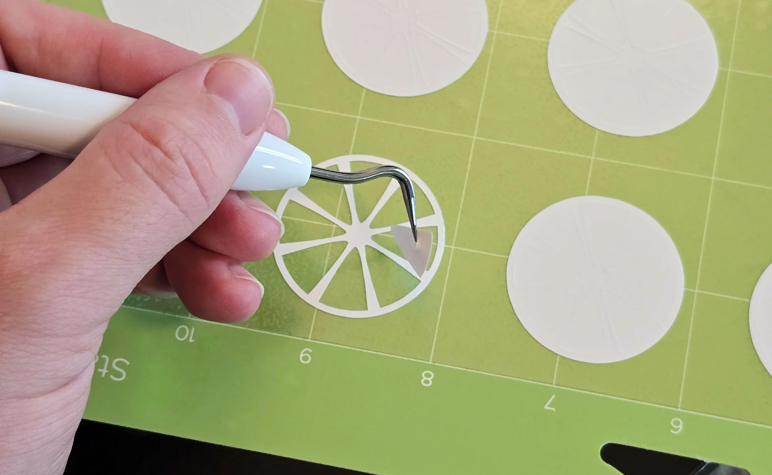 Removing excess vinyl from a cutout. I will heat press the final designs onto citrus-themed earrings