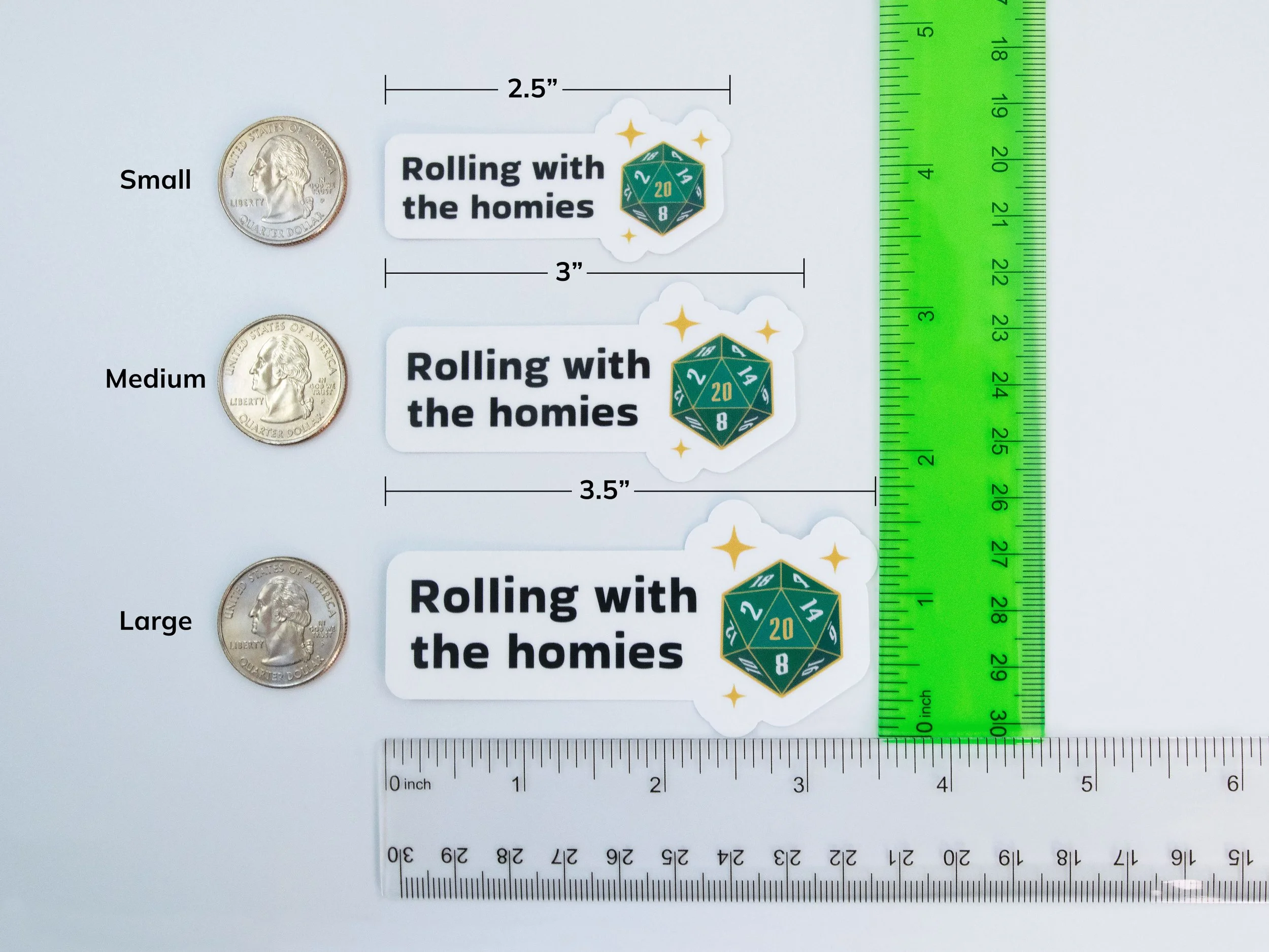 Examples of all 3 sticker sizes next to rulers and quarters to show scale. Small is 2.5” wide, medium is 3” wide, and large is 3.5” wide