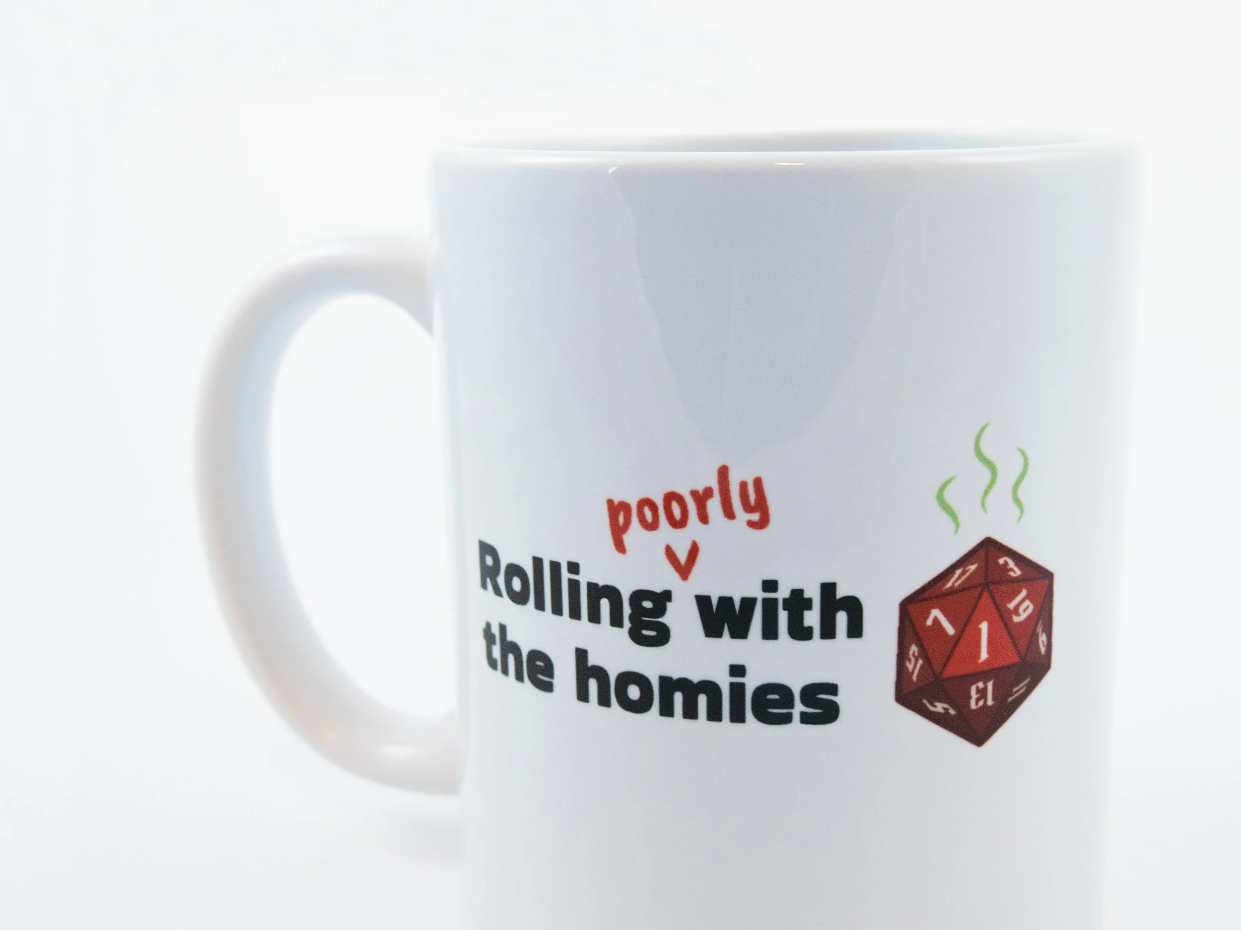 Close up view of a sublimated mug. The design says "Rolling poorly with the homies" and features a red d20 die