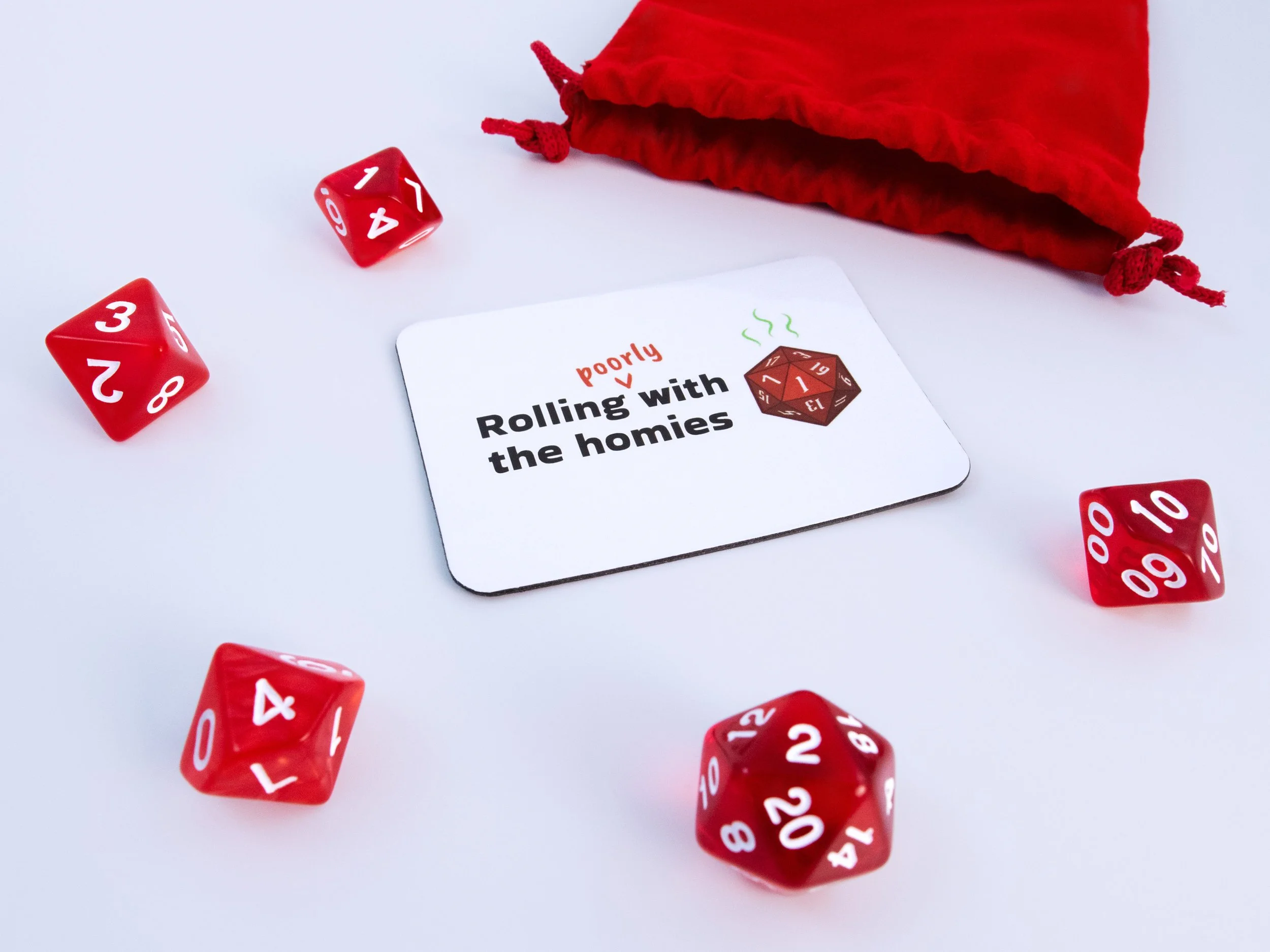 A magnet of a red d20 die with text that says “Rolling poorly with the homies”. The magnet is surrounded by red dice and a pouch