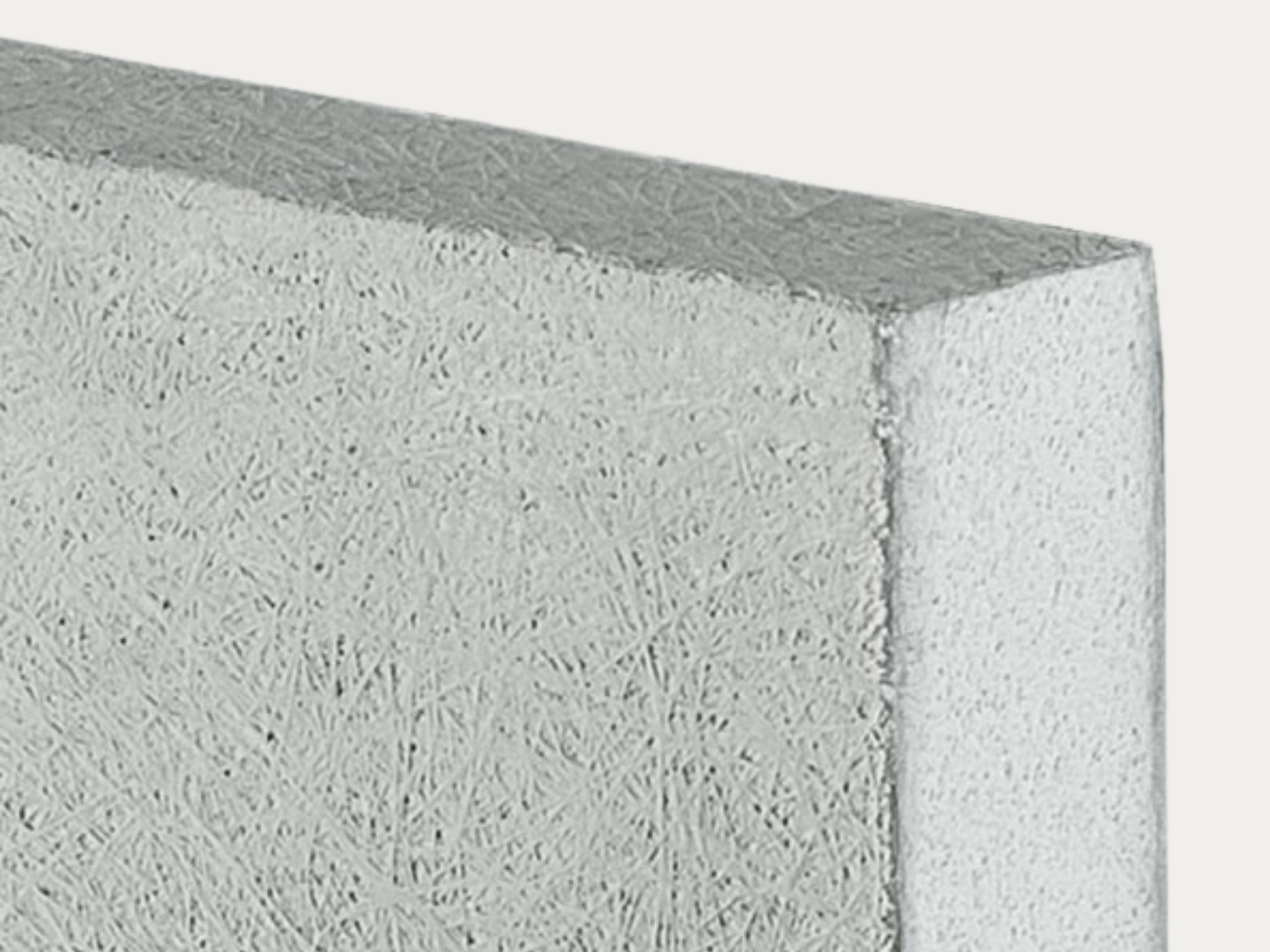 Close-up of a corner of a white textured foam block against a plain background.