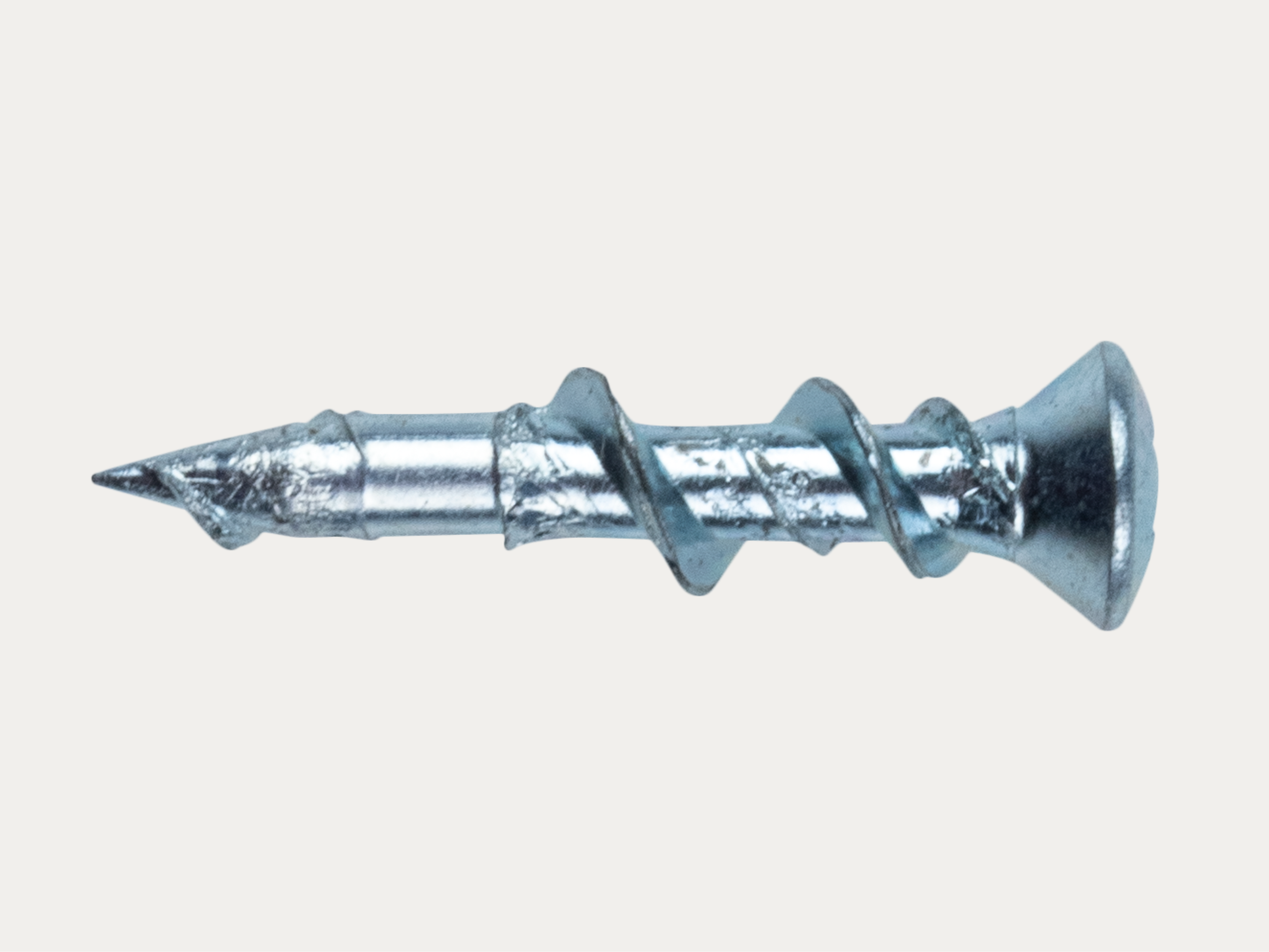 A close-up of a metallic screw with a spiral thread and a pointed tip, isolated on a plain white background.