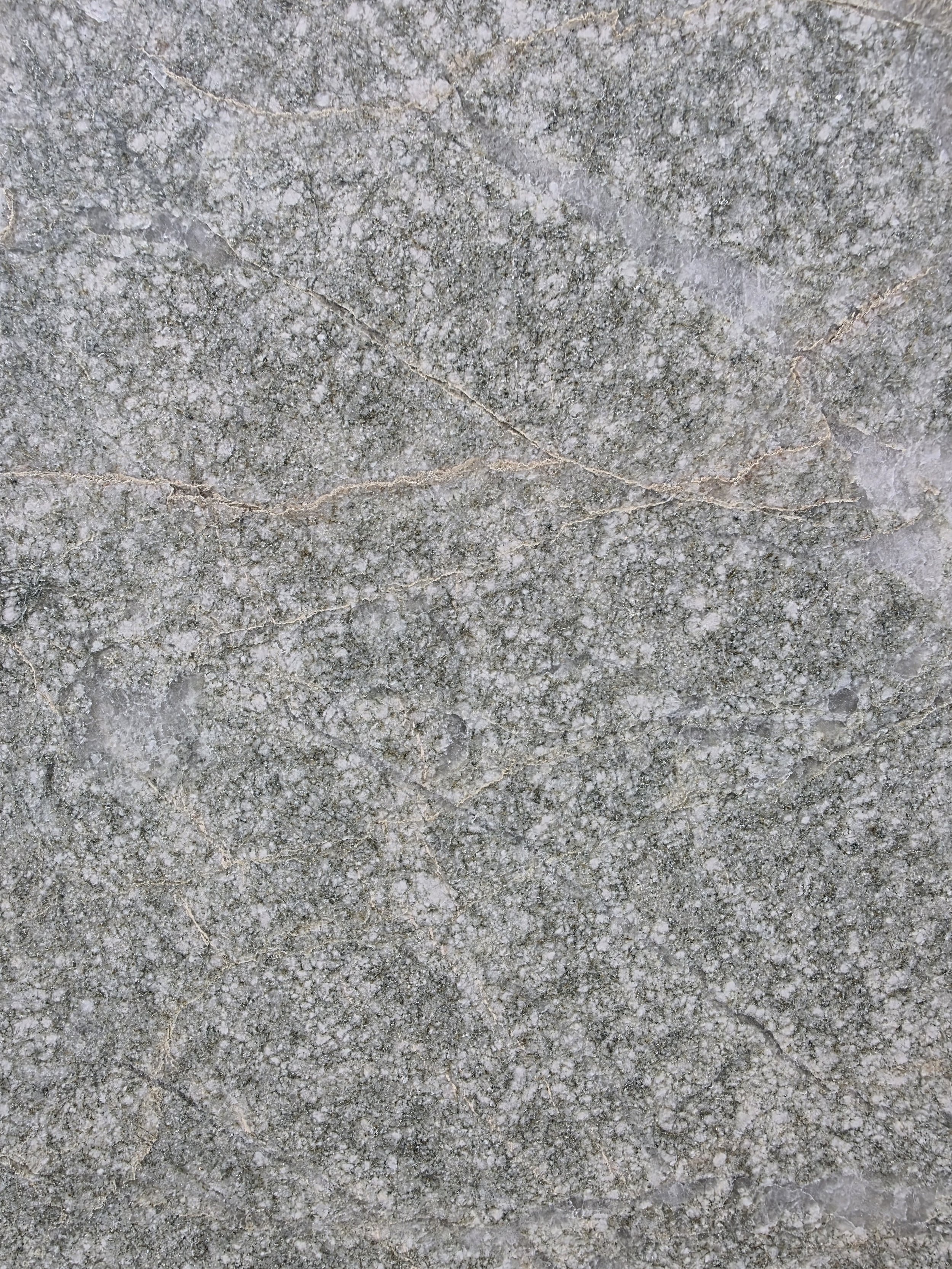 Close-up of a gray, textured marble stone surface.