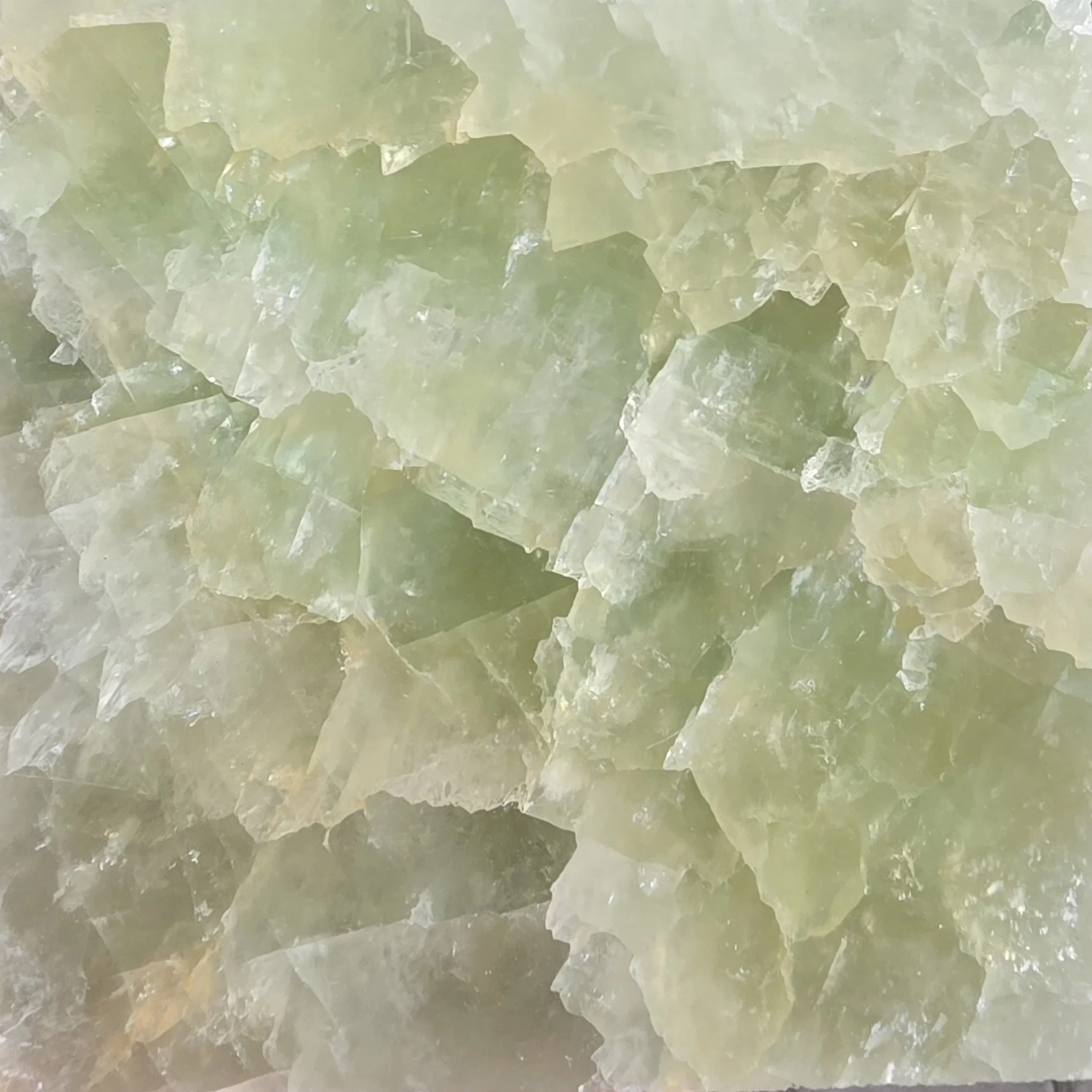 Close-up of broken light green Onyx natural stone with a rough texture.