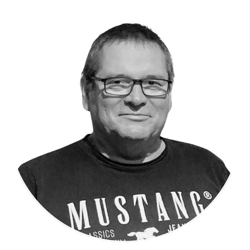 Homme portant un T-shirt Mustang avec lunettes, souriant