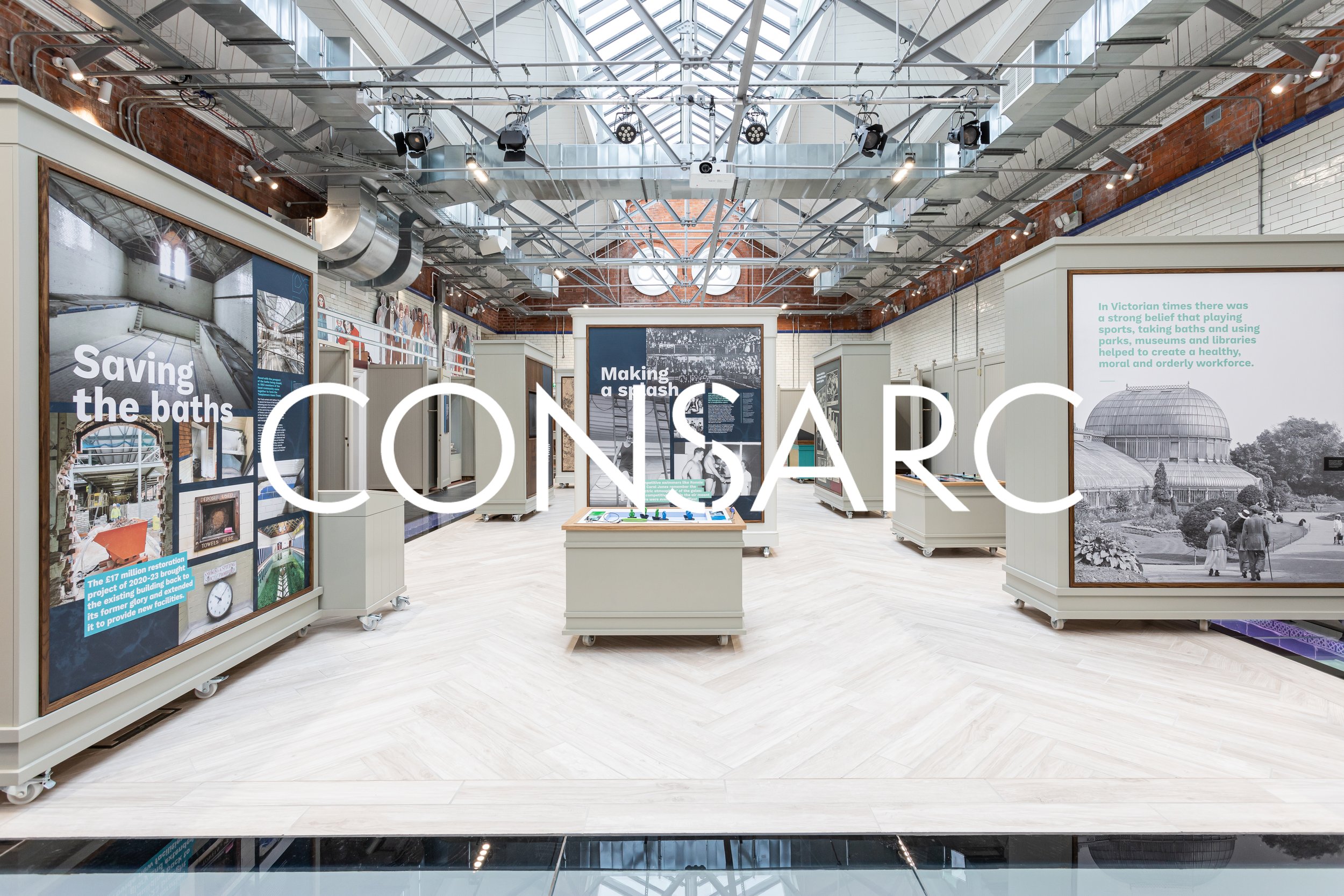 Exhibition space at the Science Museum with displays about the history of baths and architecture, featuring large informational panels and historical photographs.