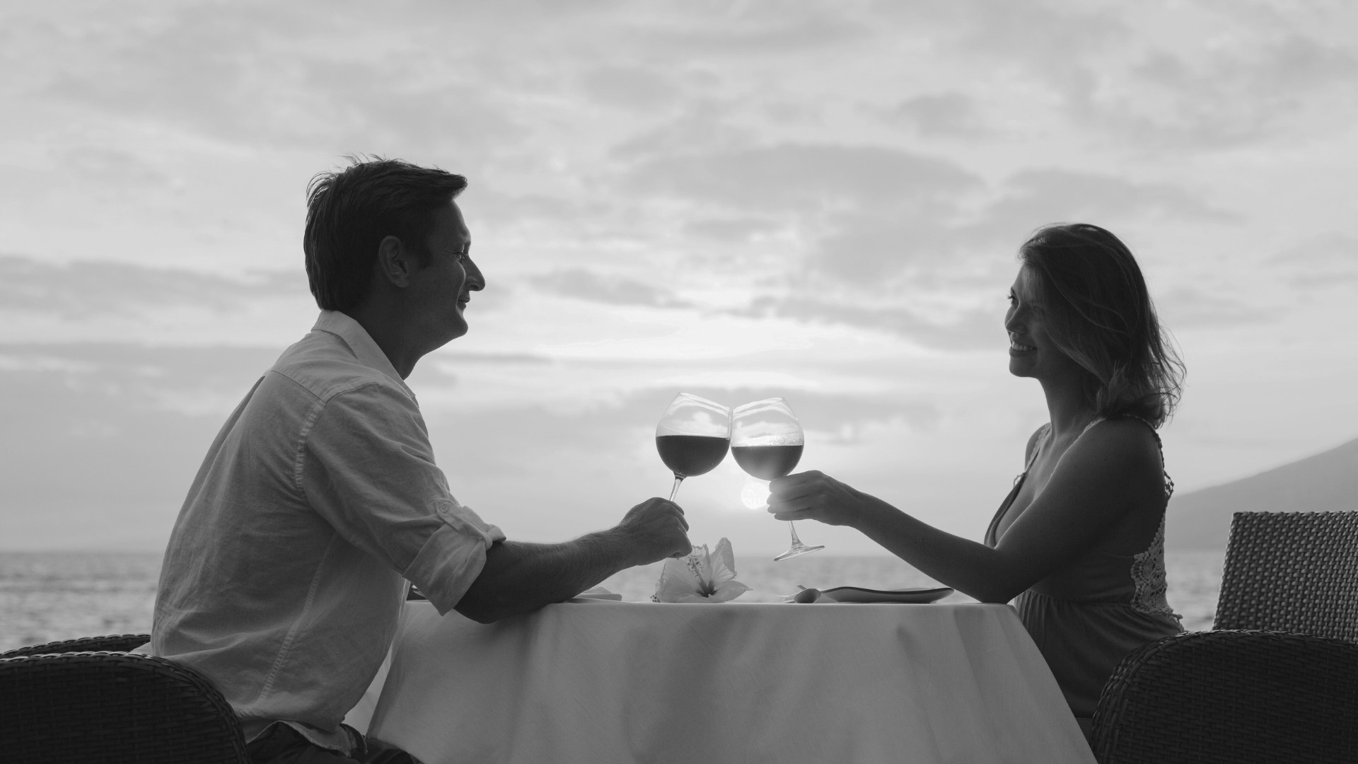 Man en vrouw proosten op het strand na een speedate event