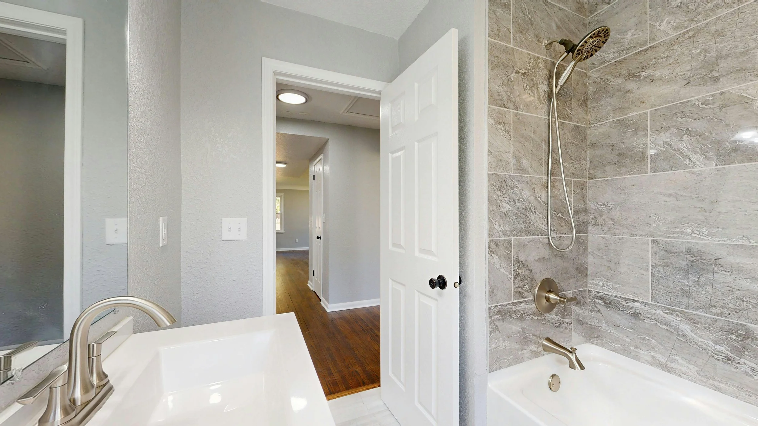 Luxury bathroom renovation with Carrara marble walls and herringbone tiles - High-end interior modernisation by MAQ Builders.