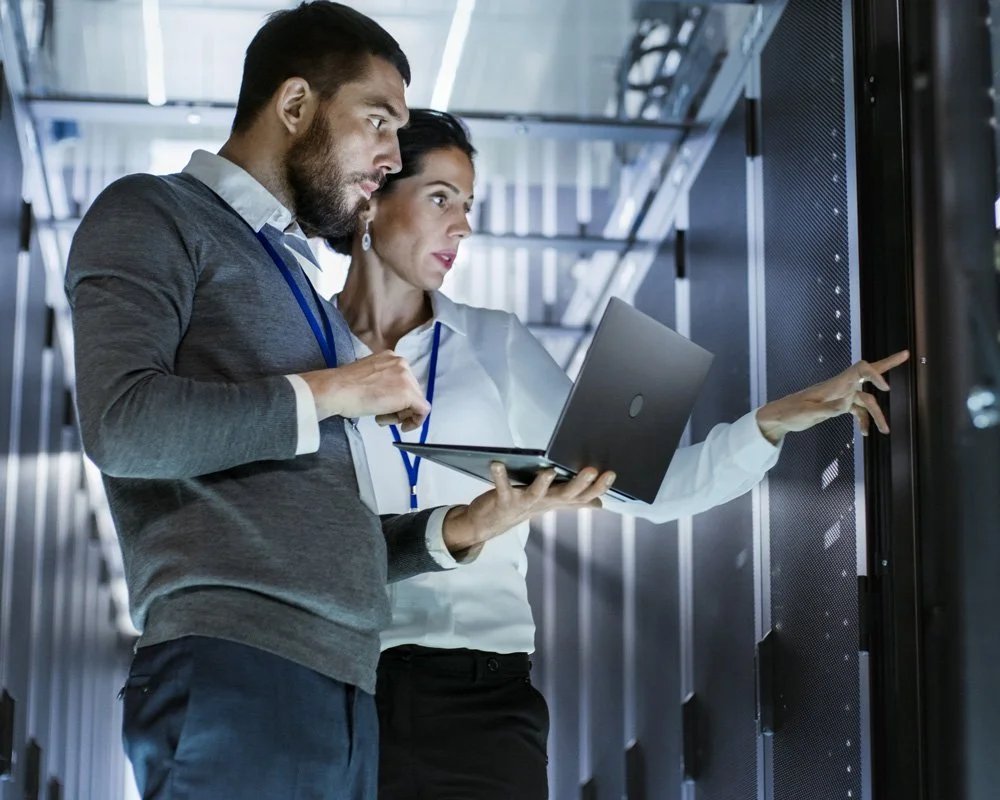 Zwei Technikingenieure untersuchen Server in einem Rechenzentrum.