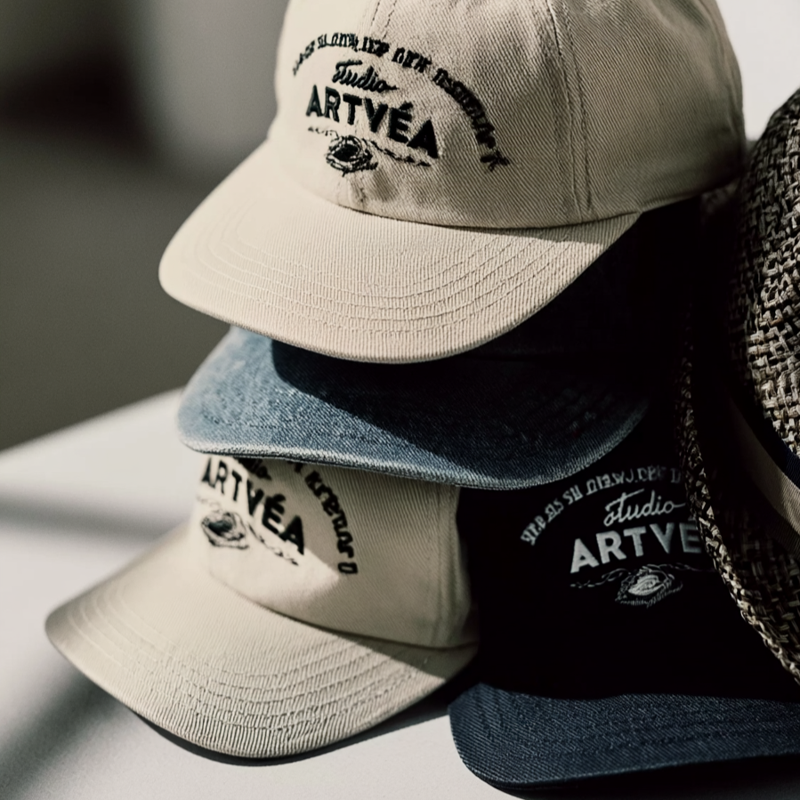 Gebrandete Caps von Studio ARTVÉA mit hochwertiger Stickerei als moderne Accessoires und textile Brand Touchpoints.